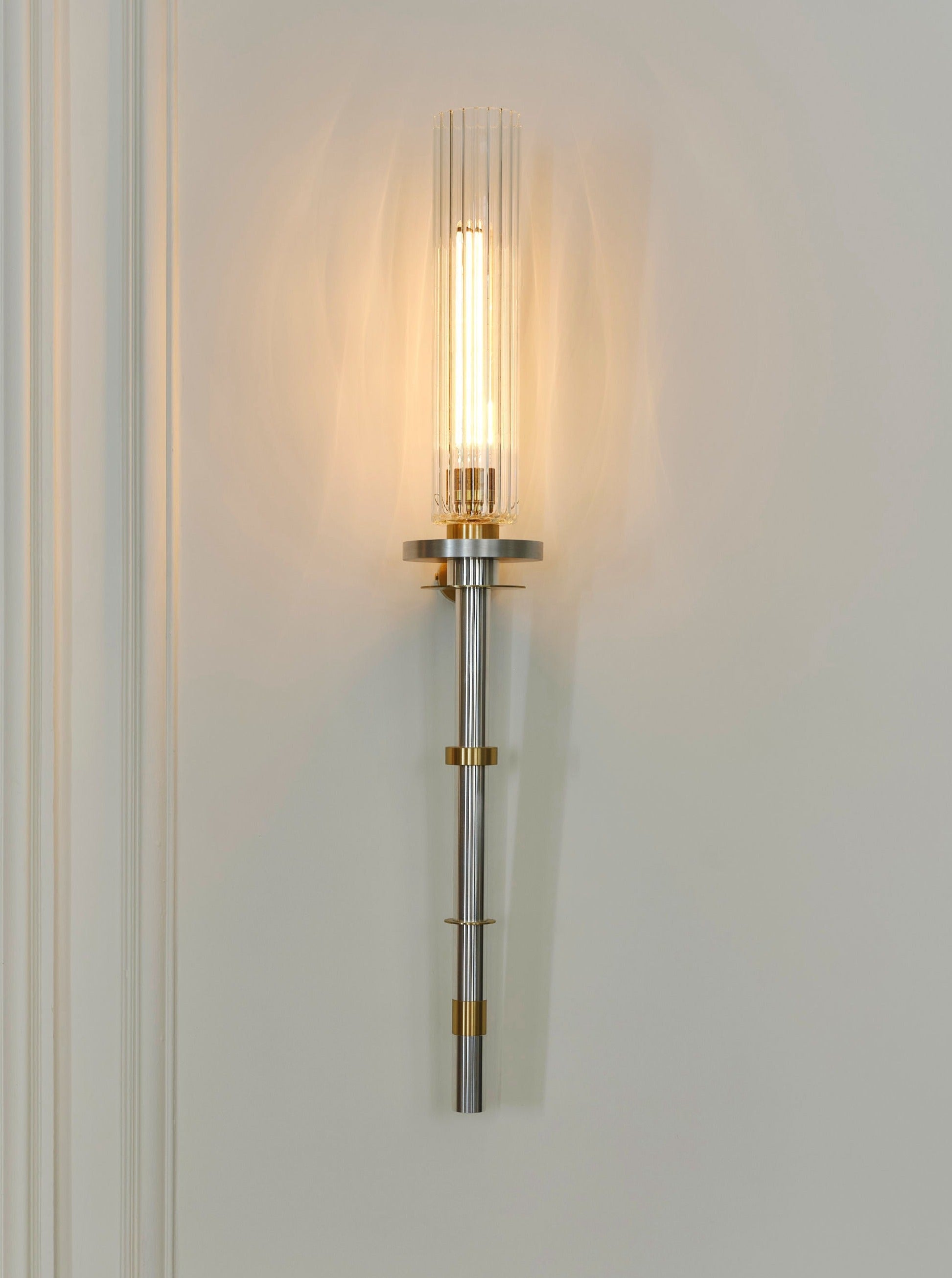 Torca Wall Light — mounted on wall with brass and glass details