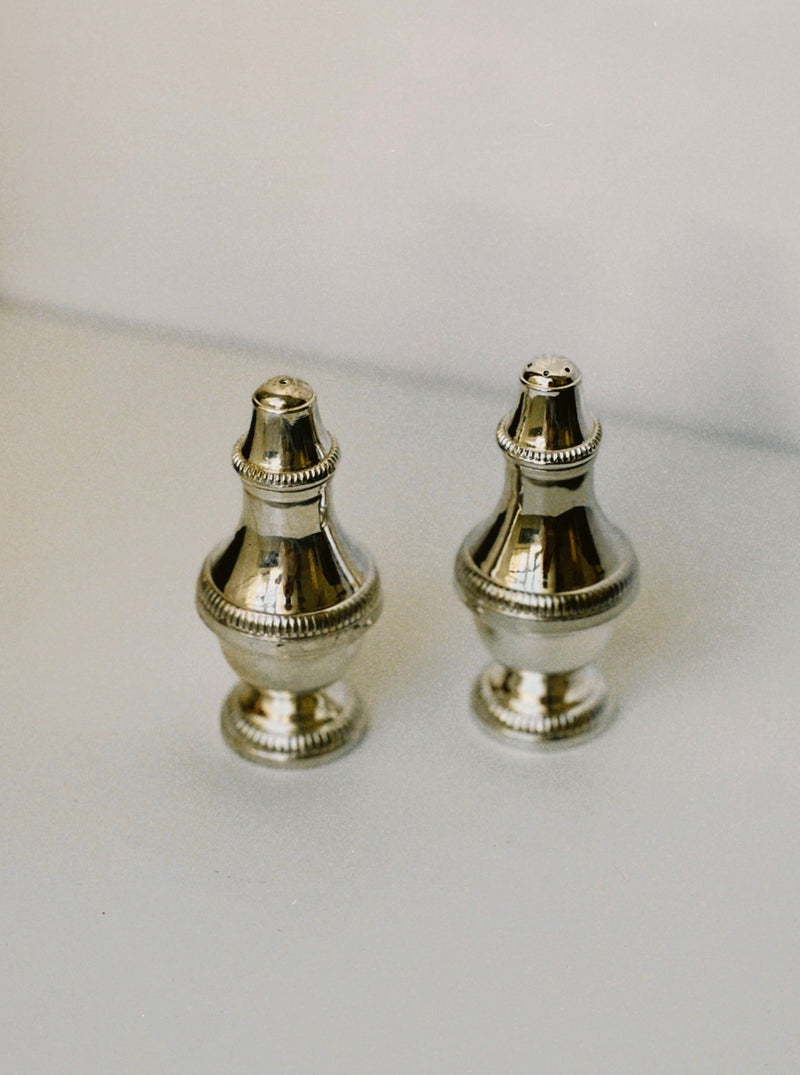 Silver salt and pepper shakers with decorative ridged details