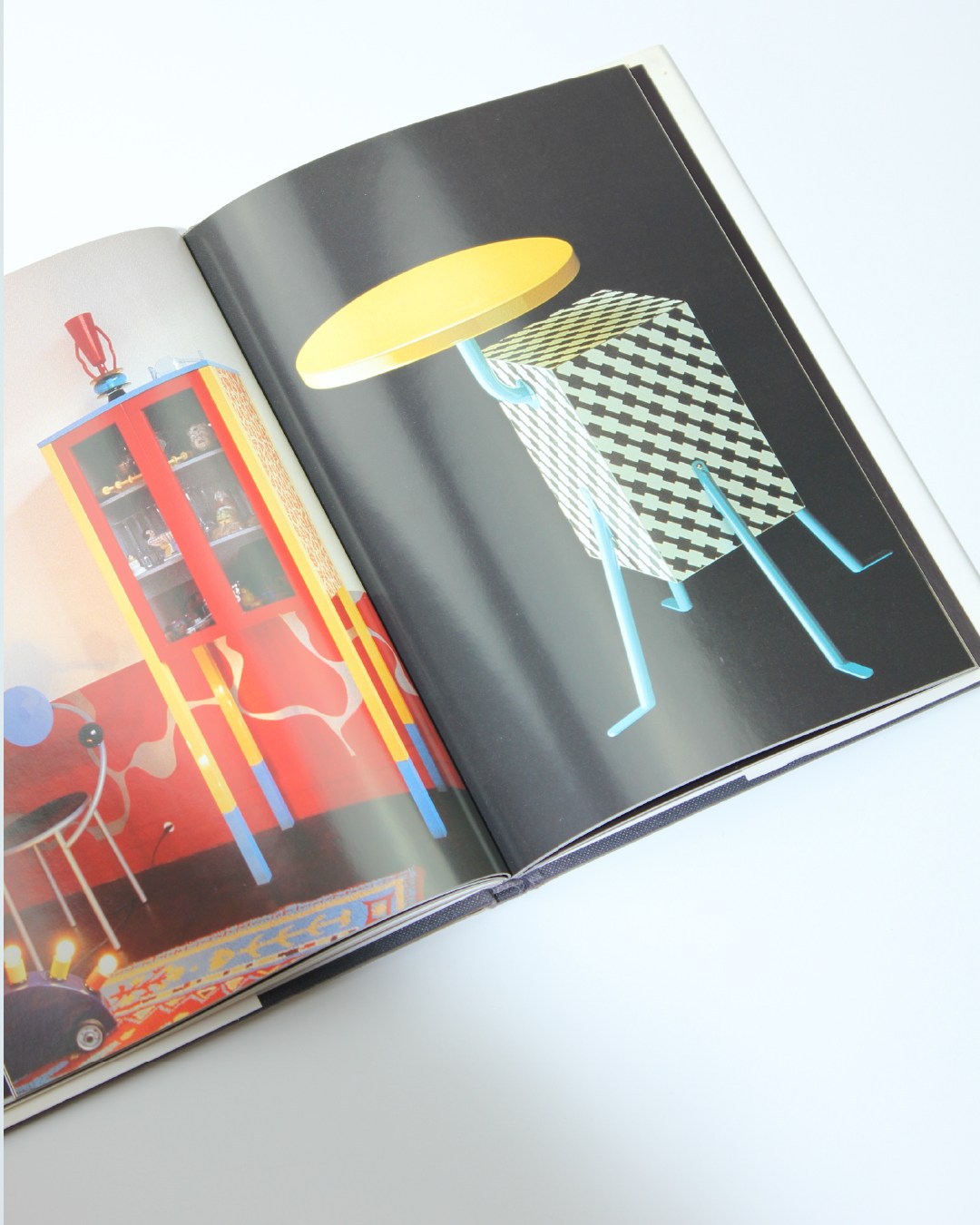 Memphis — top view of colorful book spread with furniture design