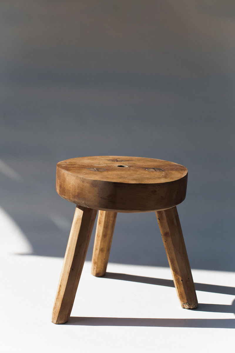 Rustic pine wood stool with three legs and round seat detail