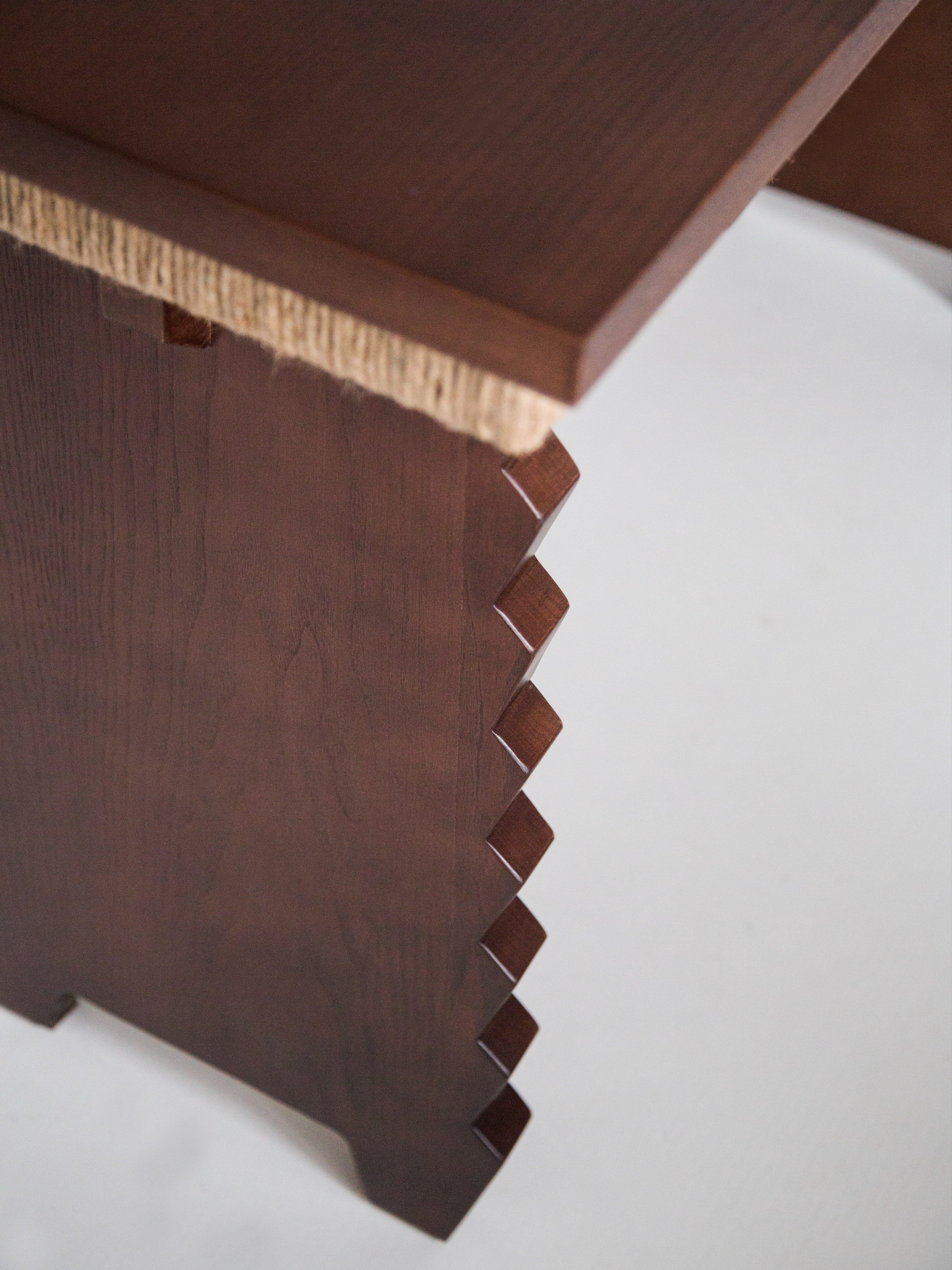 Escritorio Desk — close-up of dark wood with textured edge