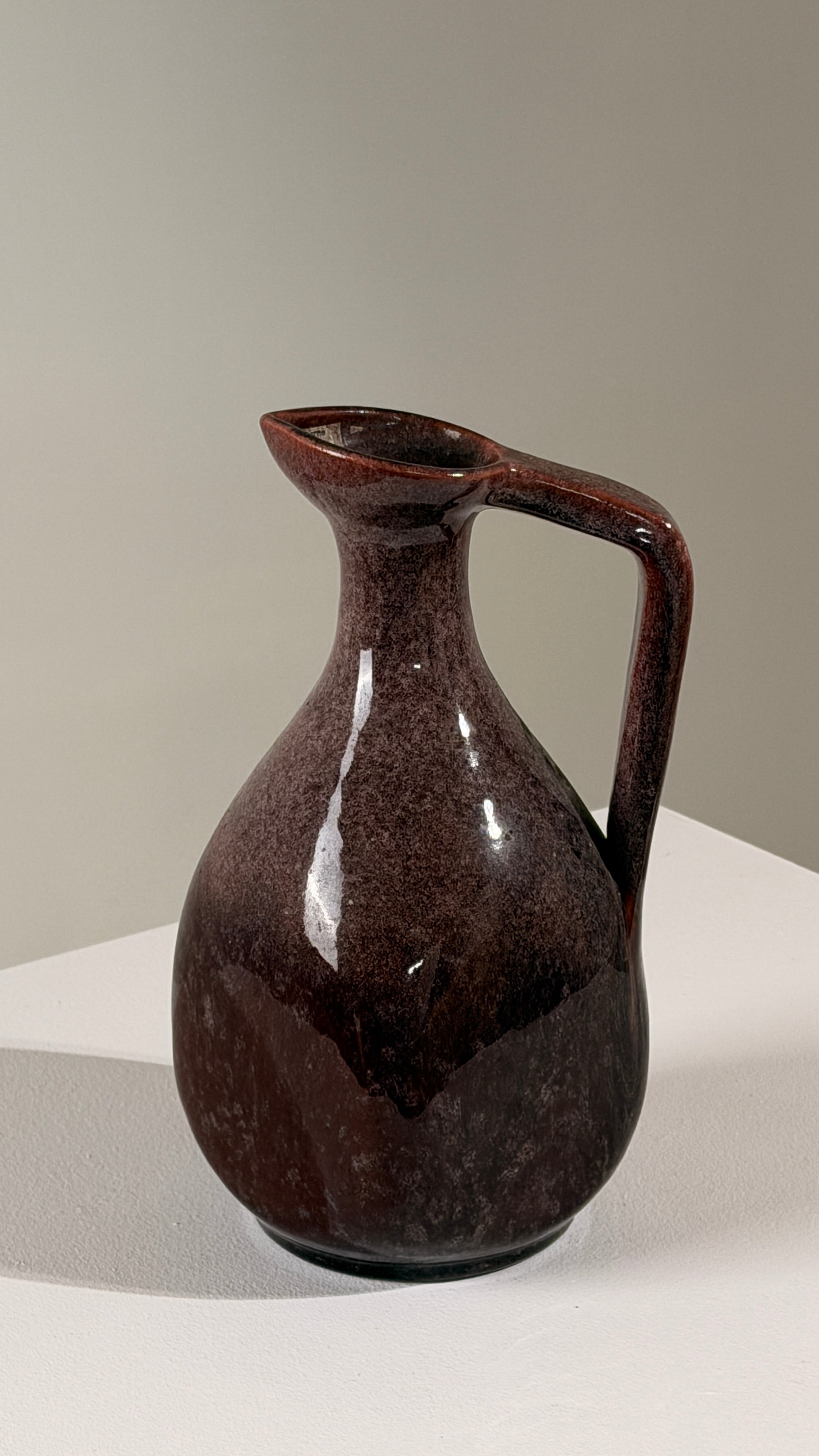 Ceramic pitcher by the Accolay potters, France, circa 1960 — close-up showing glossy dark red glaze