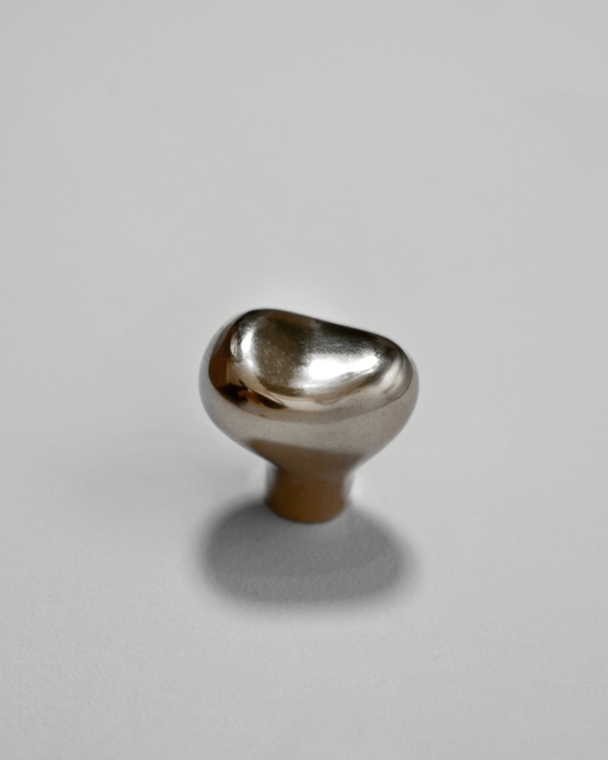 Rud Knob - Titanium — angled view on light gray surface