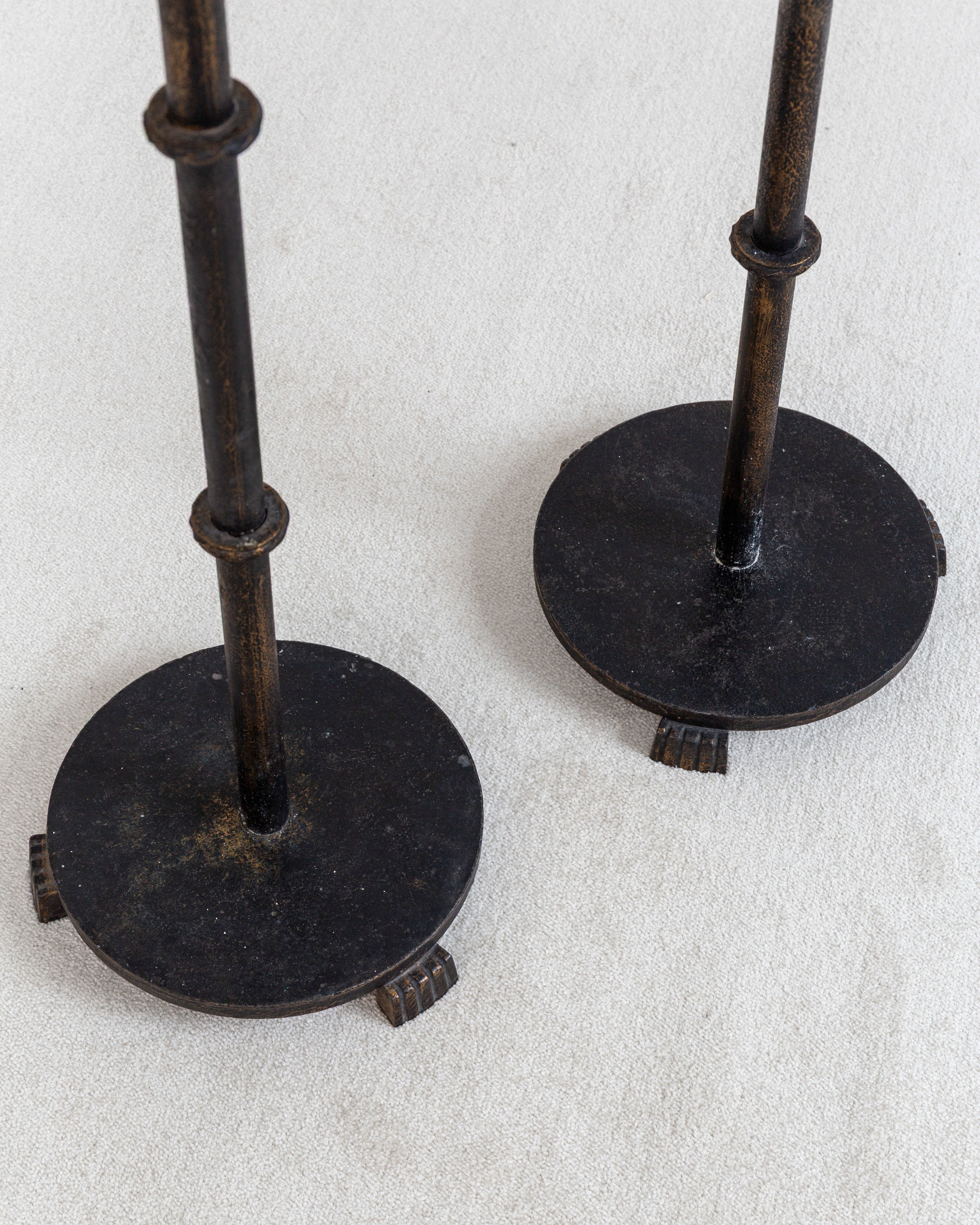 Pair of Monumental Cast Iron Floor Candleholders by Böhlmarks, Sweden, 1930s — close-up of round bases on light fabric backgr