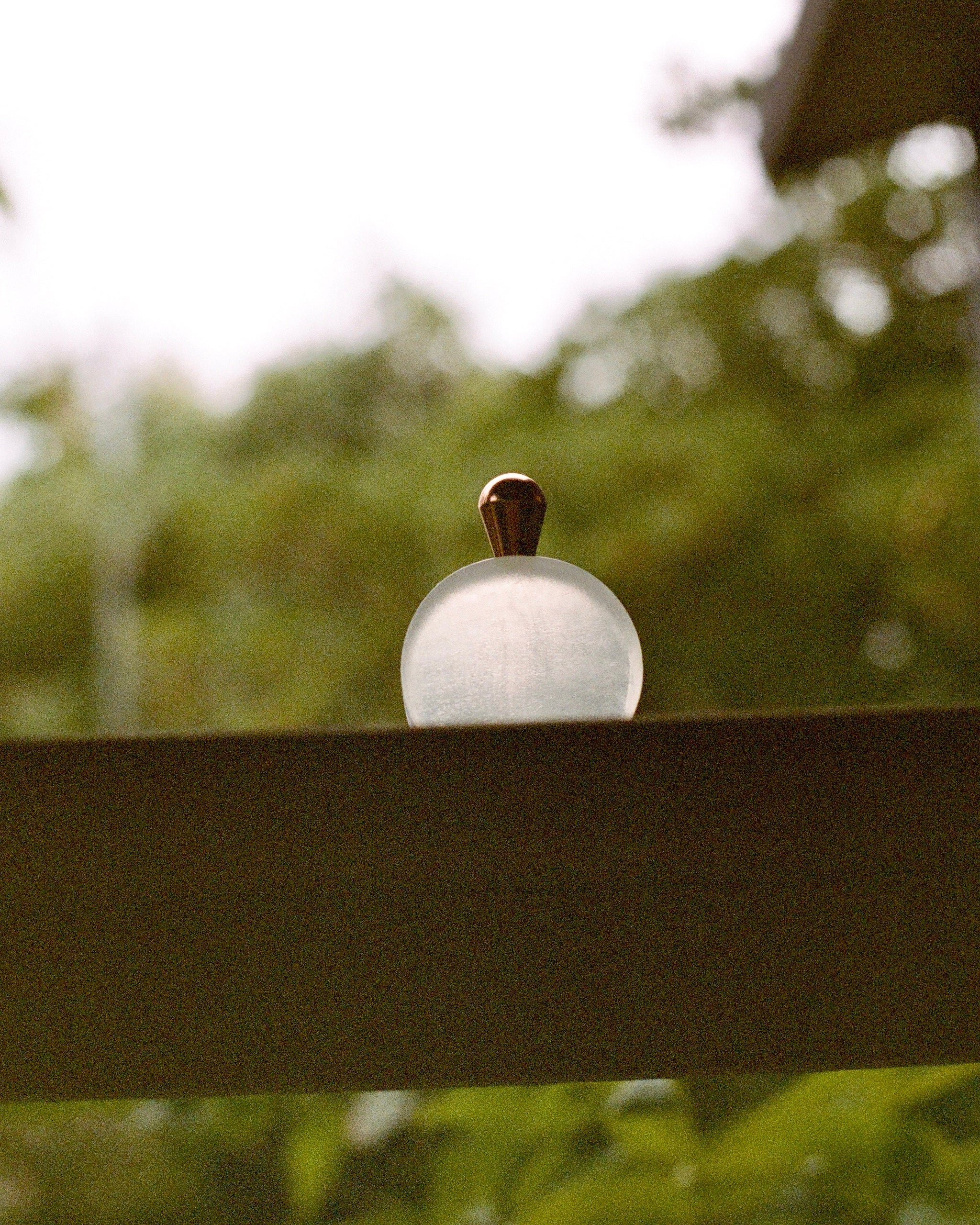 LUA Cabinet Knob — close-up on glass knob against blurred greenery