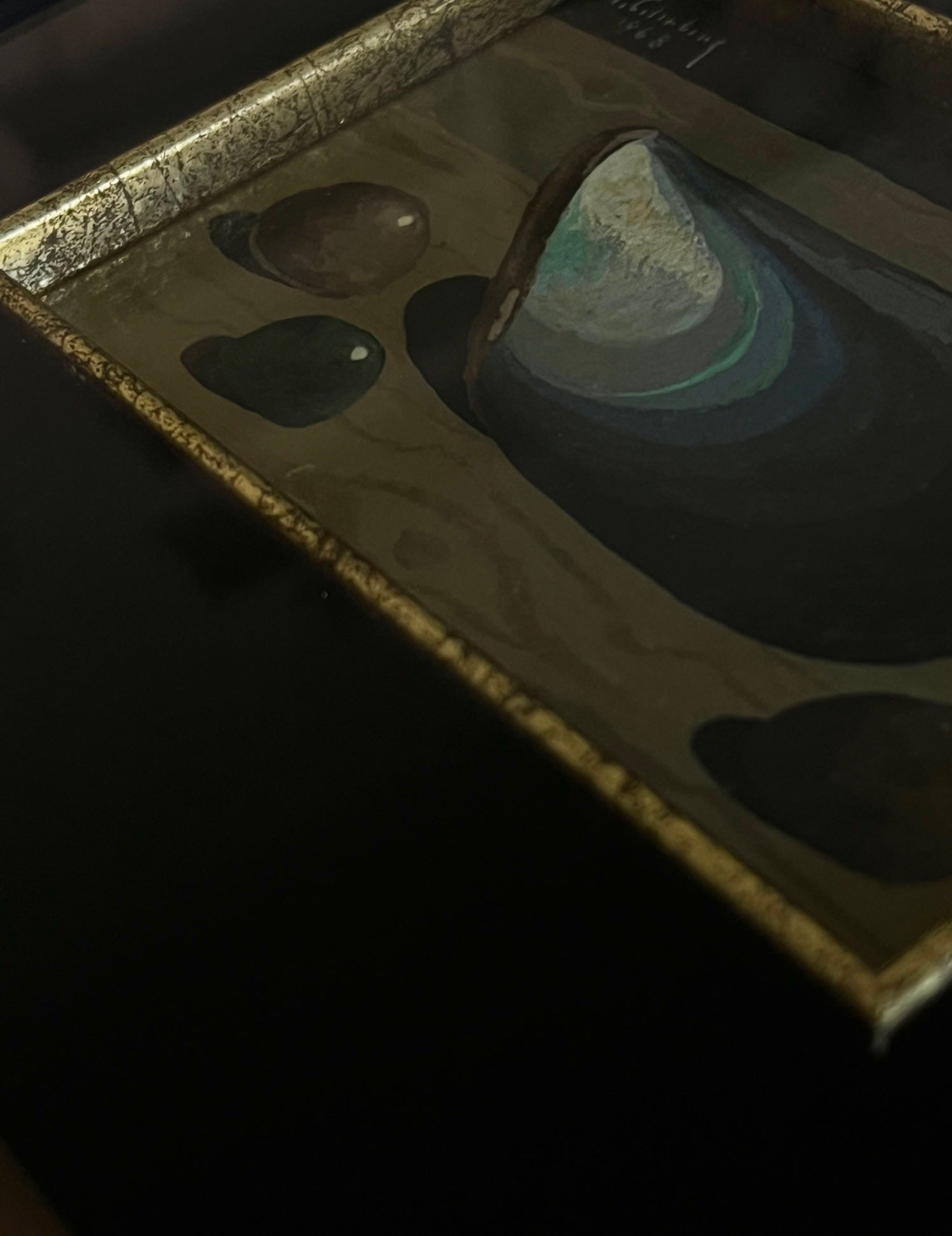 Still Life with Blue Mussel and Stones, 1968 — angled view on dark surface