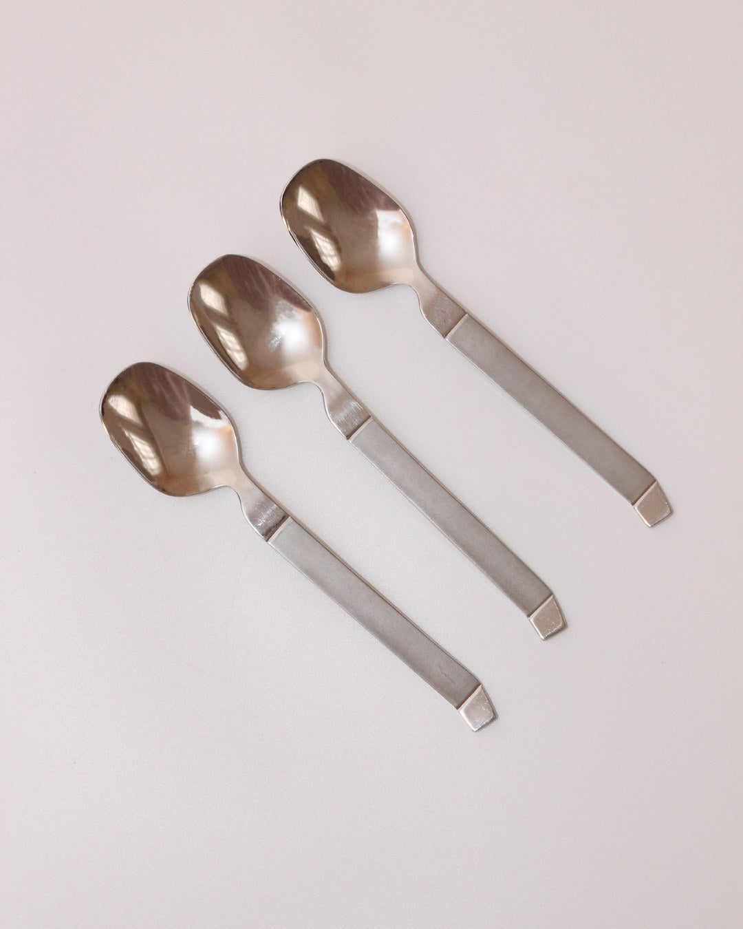 Stainless Steel Cutlery Set — close-up of three spoons on light background