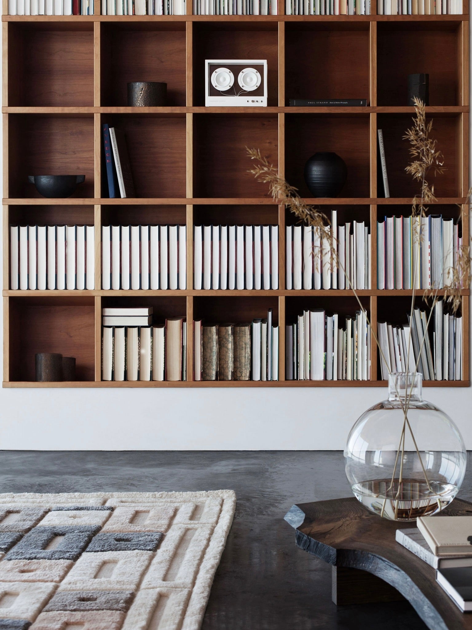 Small Transparent Speaker White - Bluetooth — positioned on wooden shelf with books
