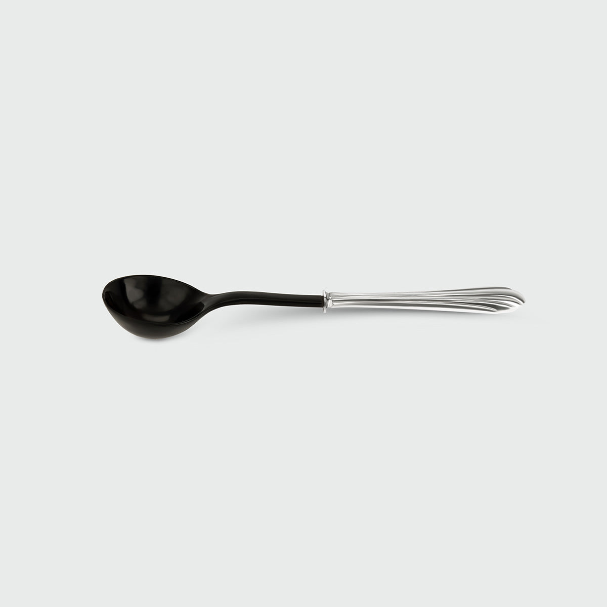 Ossu Black Spoon — side angle showing black ceramic bowl and silver handle