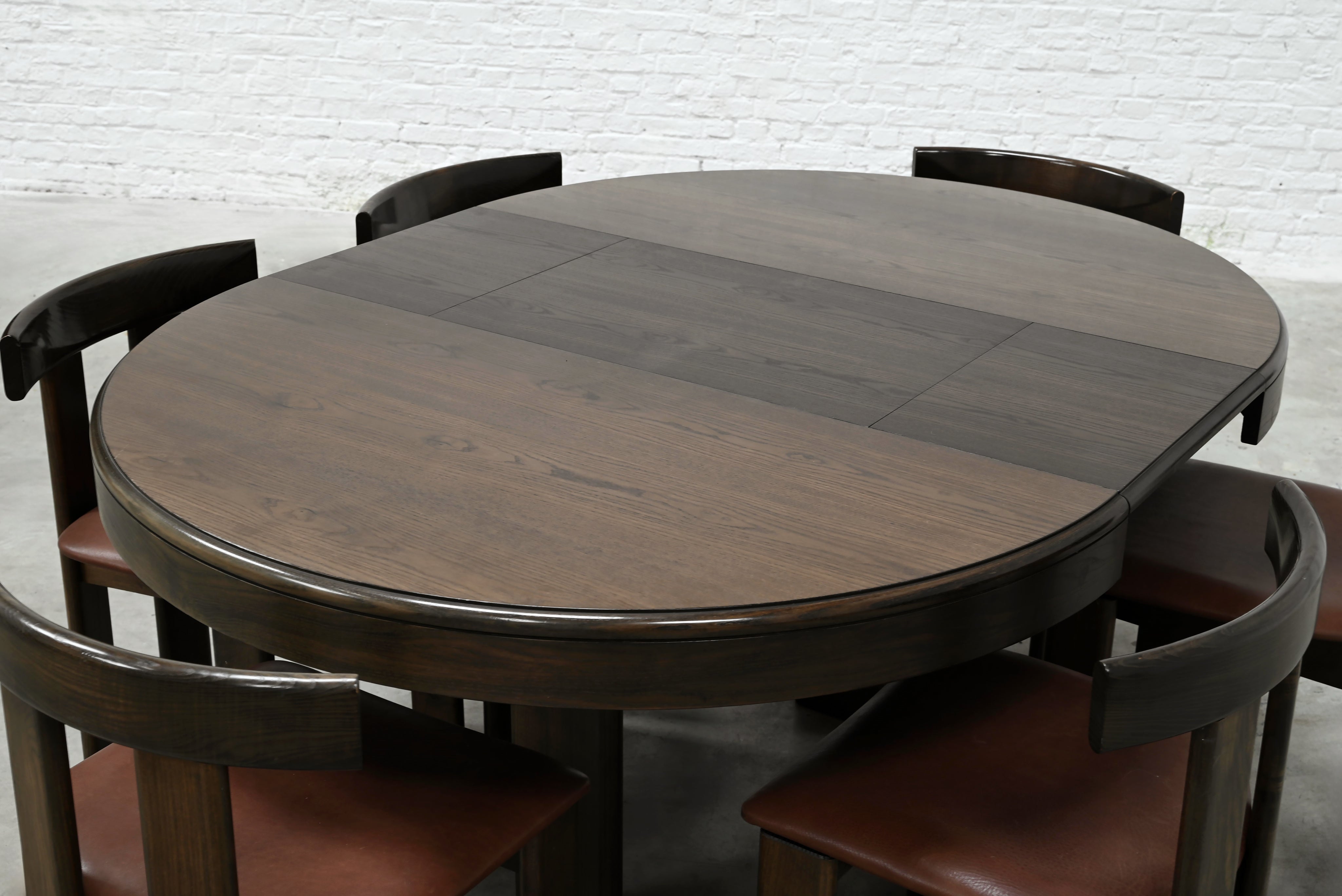 Close-up detail of round dining table with leather chairs by Luigi Vaghi