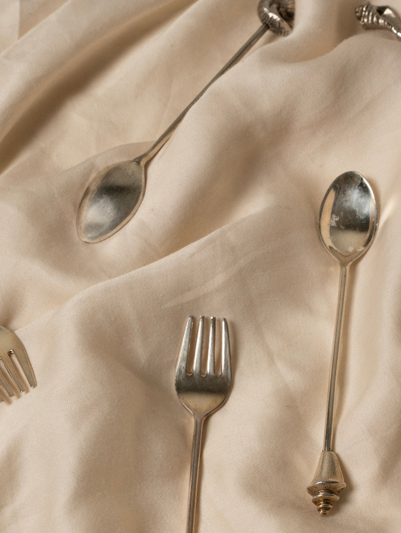 Silver Shell Spoon Set of Two — close-up on silver spoons on fabric