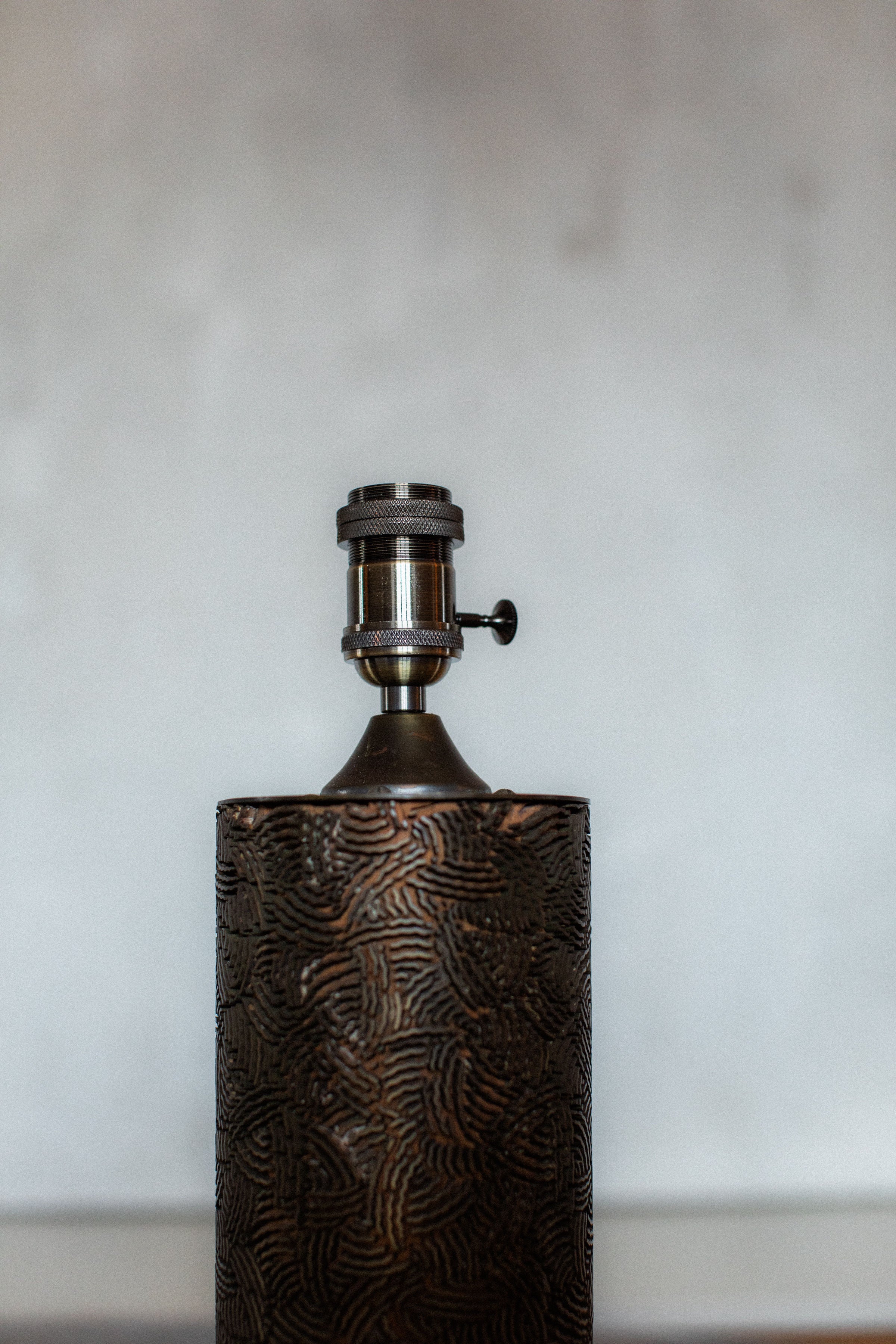 Textured bronze ceramic table lamp base with industrial socket detail