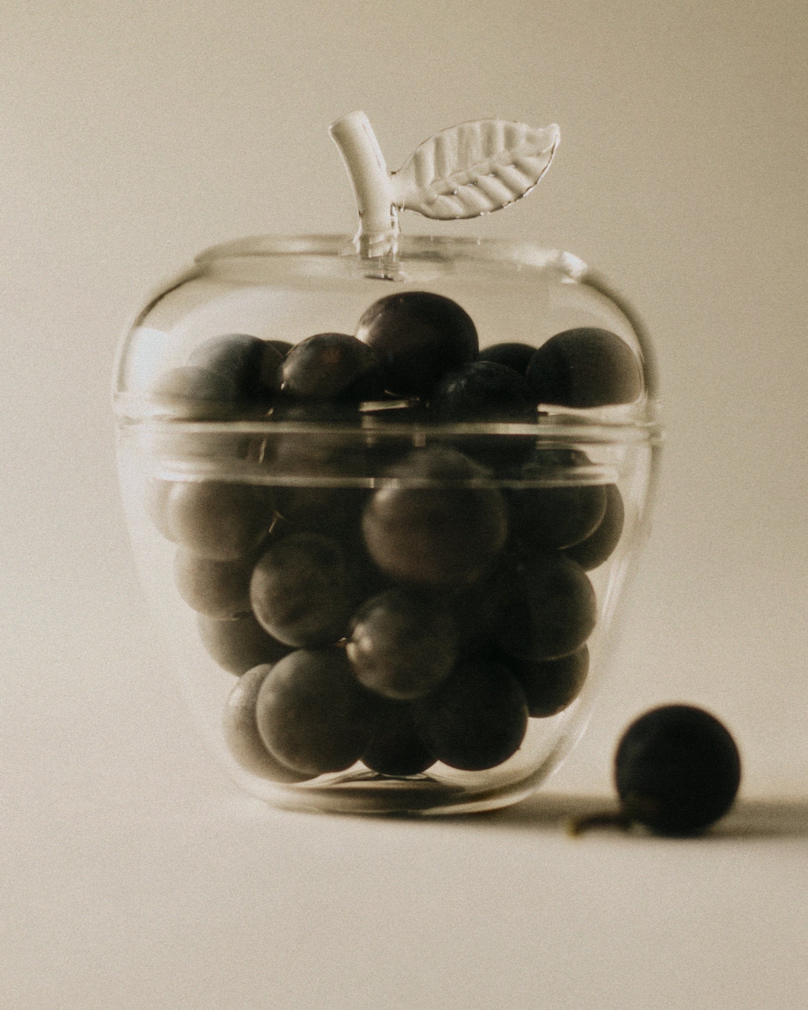 La Pomme — close-up of glass container with dark fruit