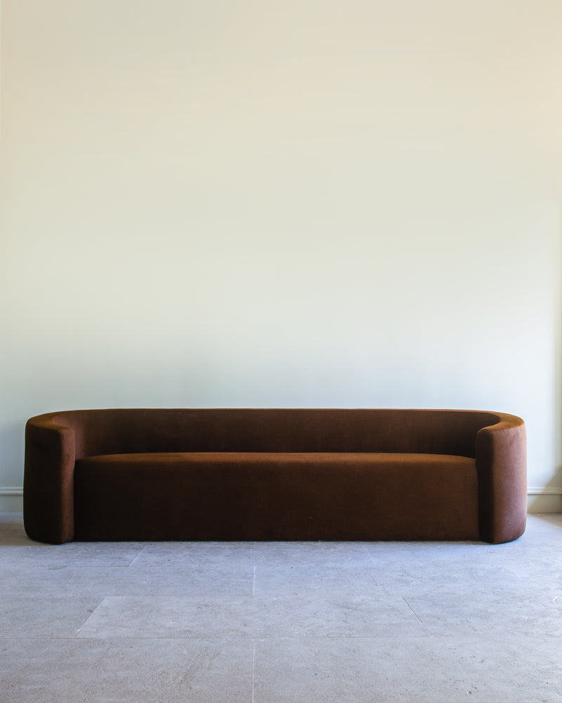 Curved brown velvet Trousdale sofa with rounded arms by Studio OSKLO