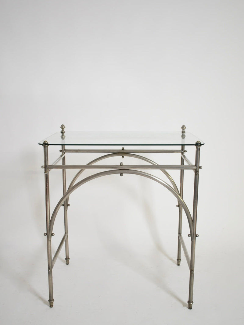 The Tubular Chrome Iron and Glass Table, 1920s by Barracuda Interiors features a minimalist chrome frame, rectangular glass top, and arched metal supports, shown against a plain white background.