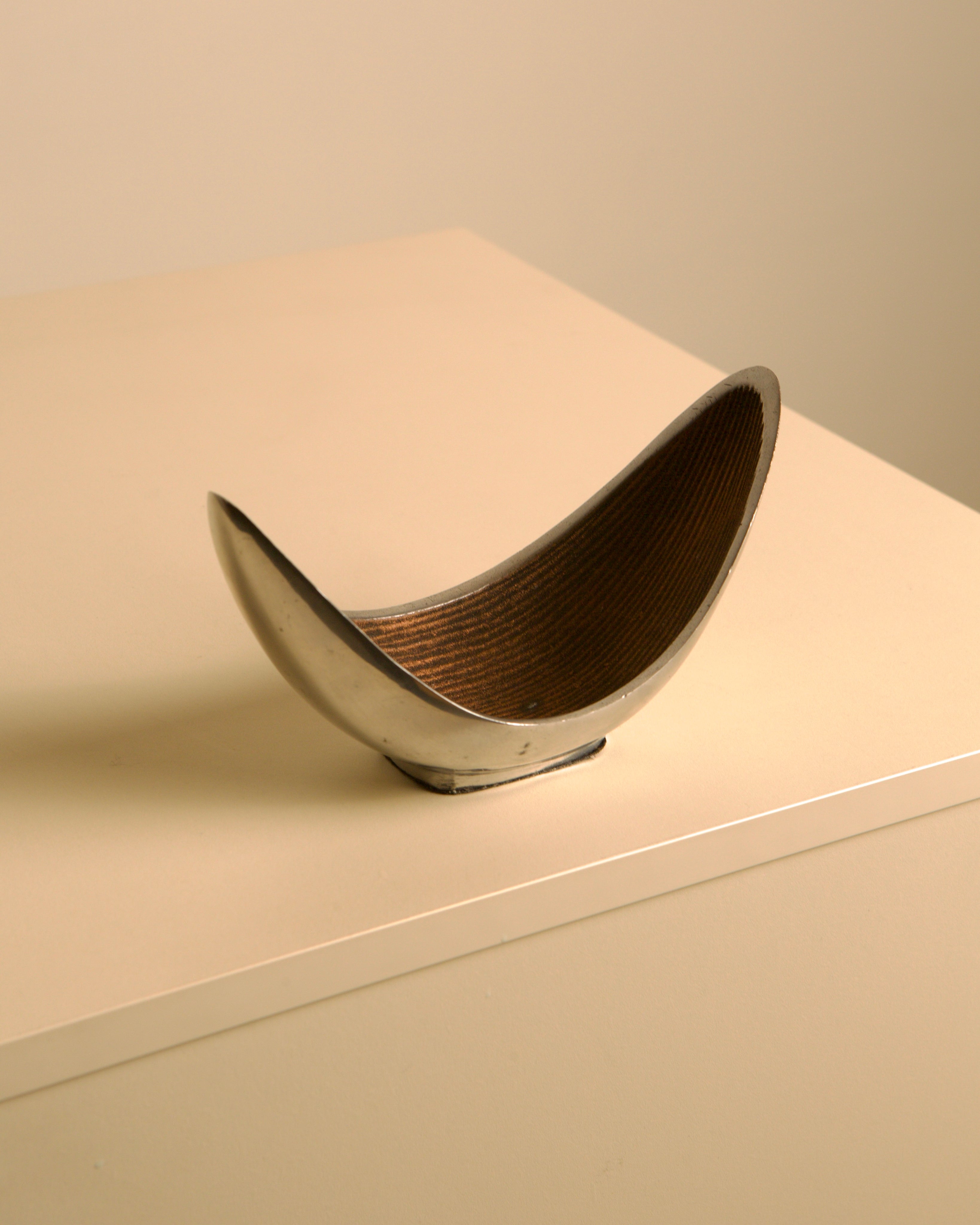 Italian "Croissant" Trinket Tray in cast aluminum — side angle on neutral surface