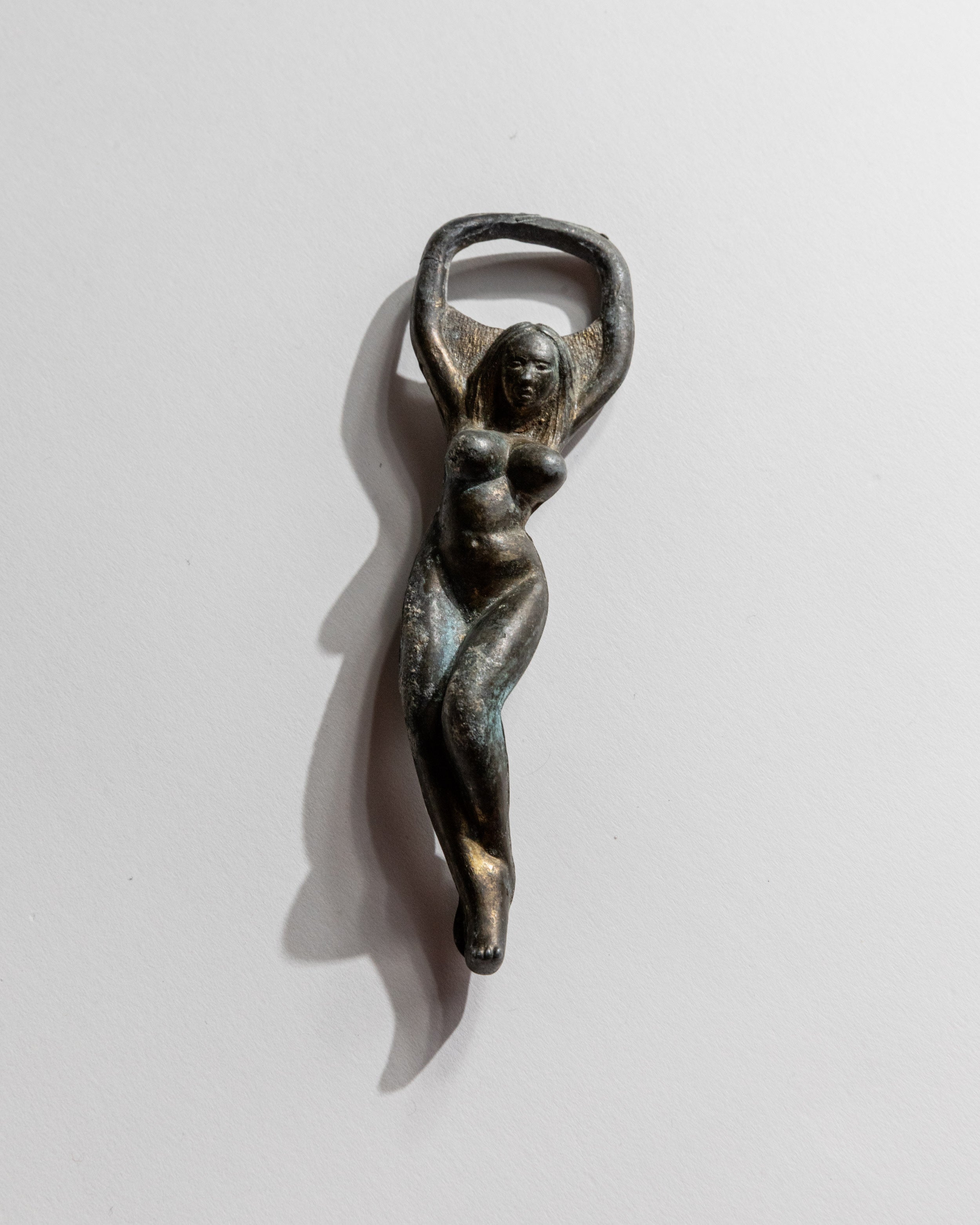 Vintage 1940s Bottle Opener Brass, Nude Woman Shape — close-up of brass figure on white background