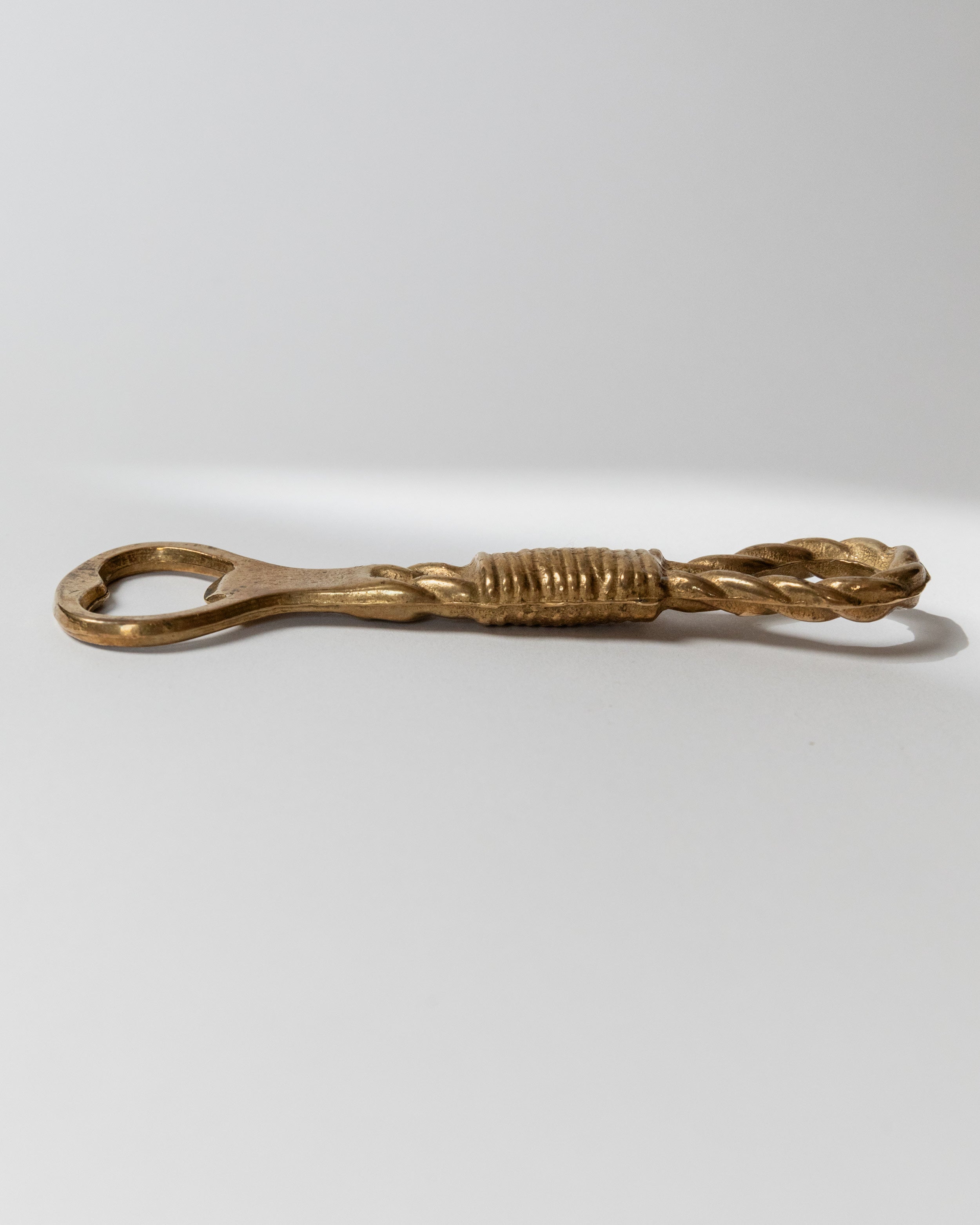 Brass bottle opener side profile view showing decorative ribbed handle Italy 1960s