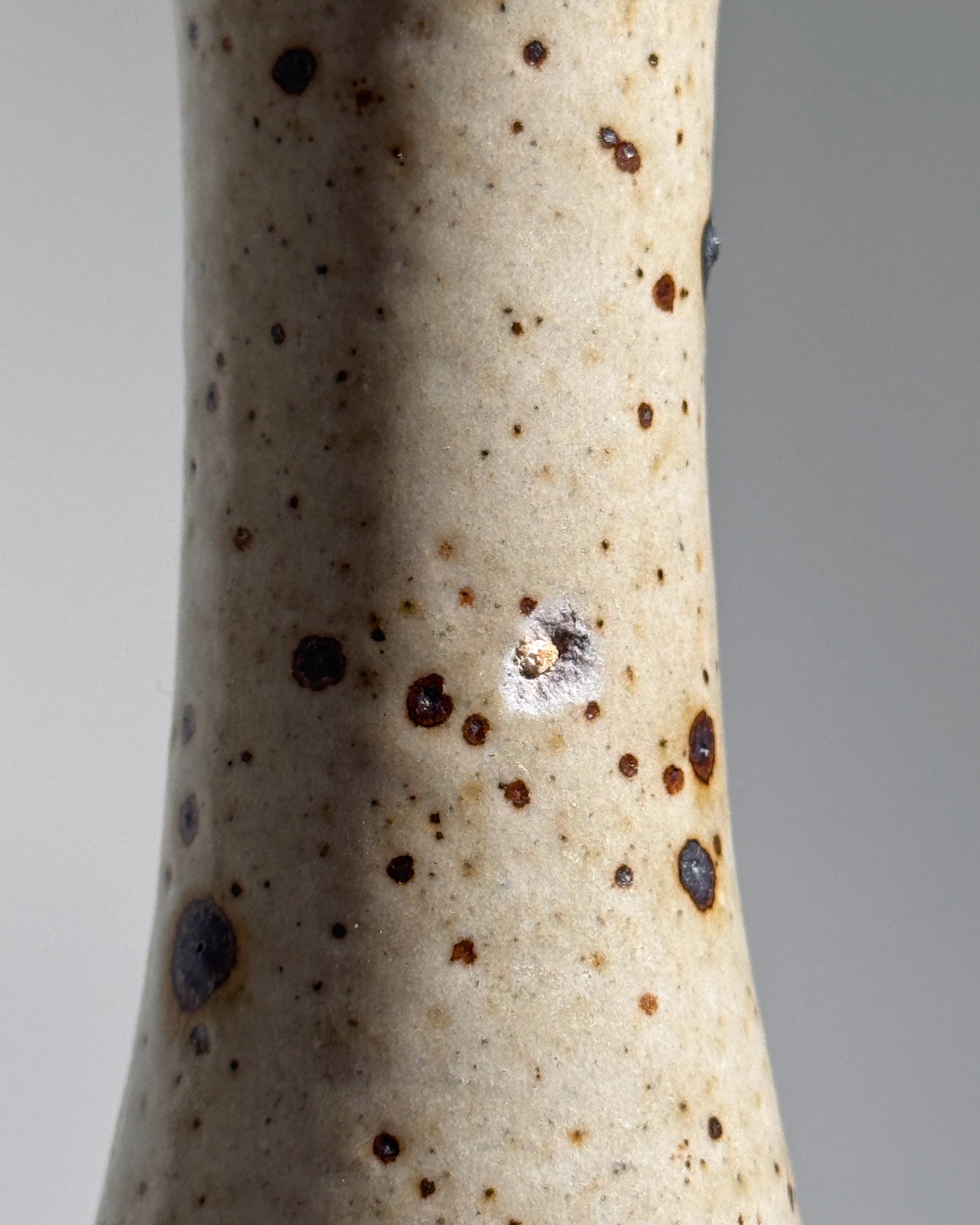 Speckled stoneware vase surface detail showing natural clay texture