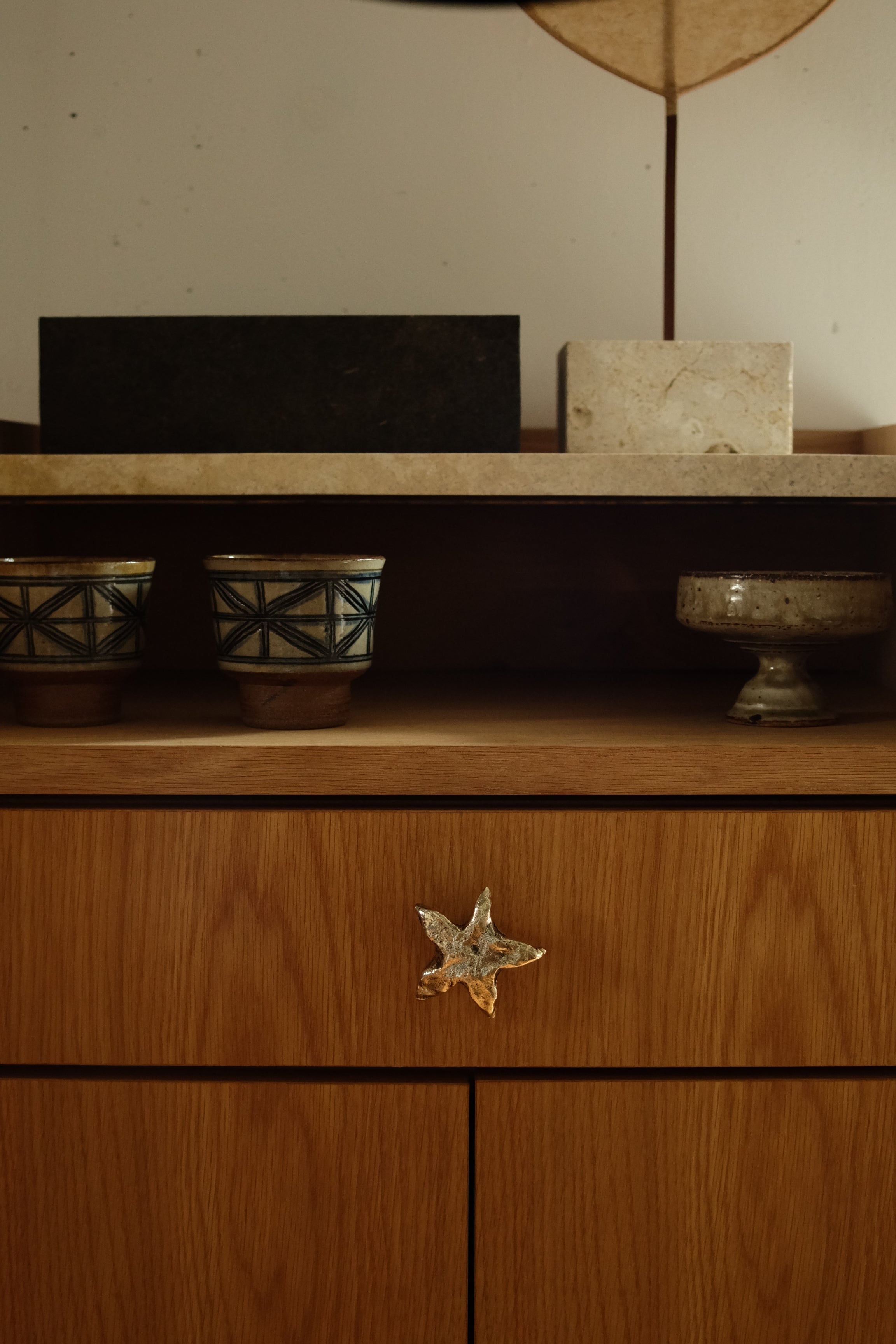 STAR Cabinet Knob/Wall Hook — close-up on wooden cabinet with ceramic pots