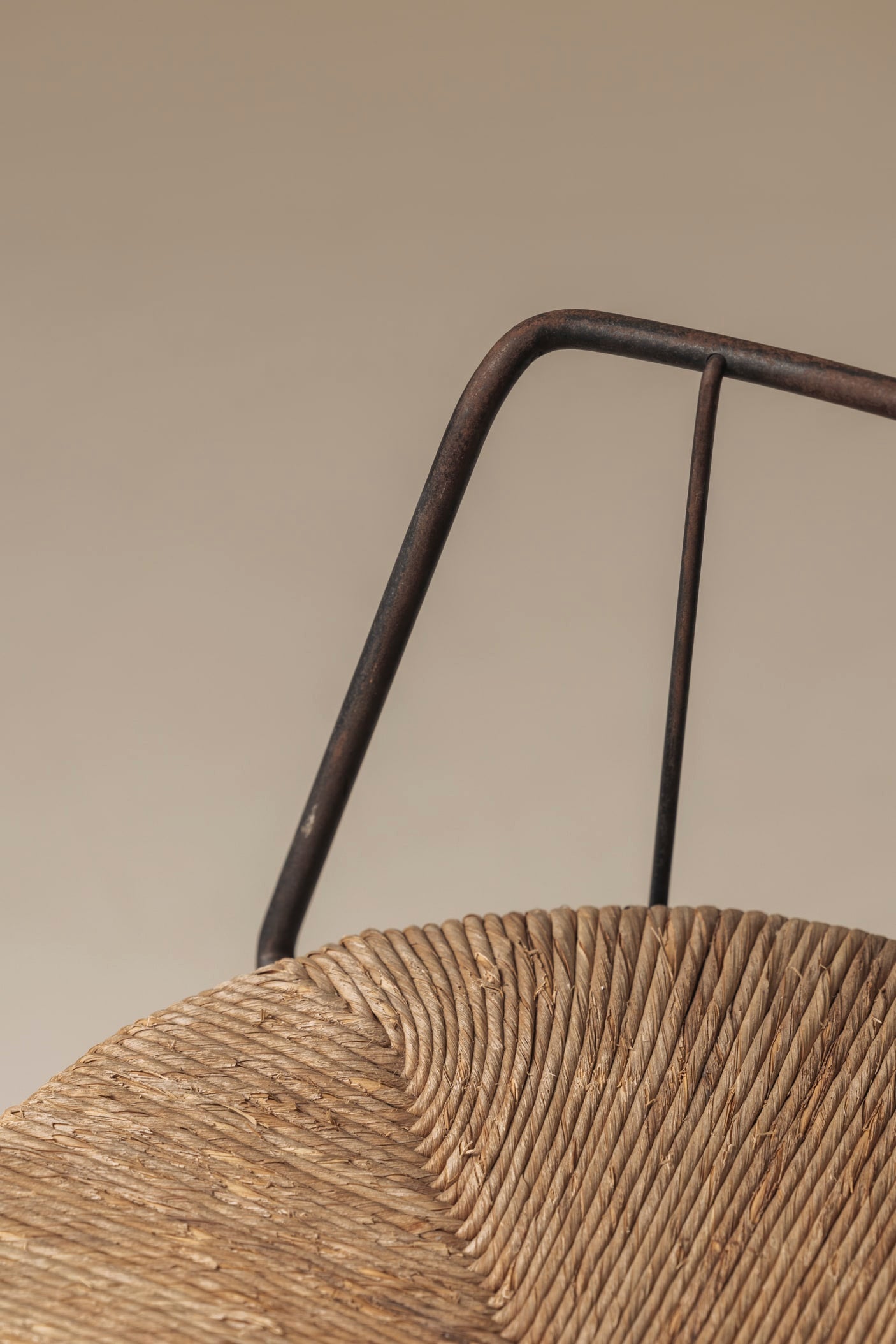 Rare French tripod stool in metal and rush, dating from the 1950s — lifestyle setting