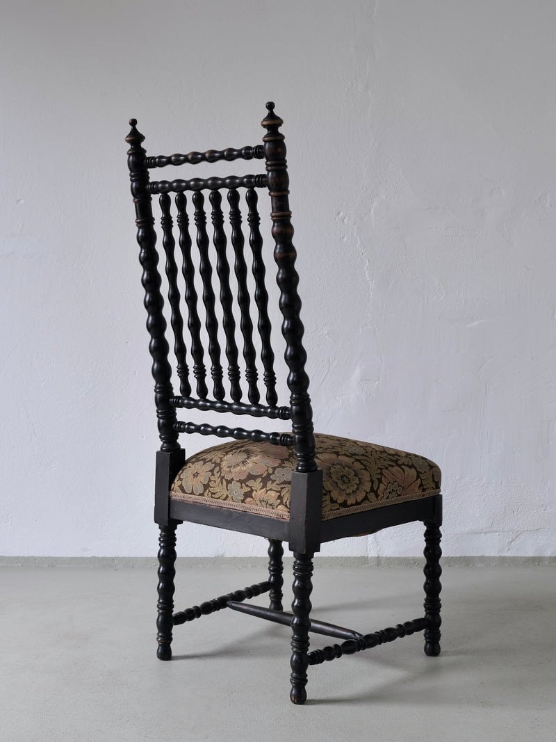 Antique French oak bobbin chair profile view with ornate spindle back