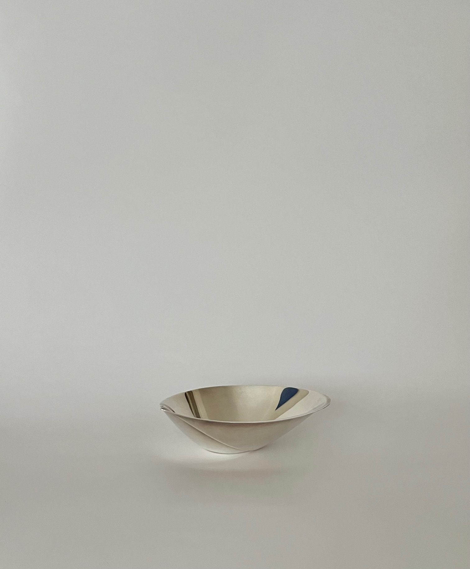 Tapio Wirkkala Silver Bowl 1957 — angled view on neutral background