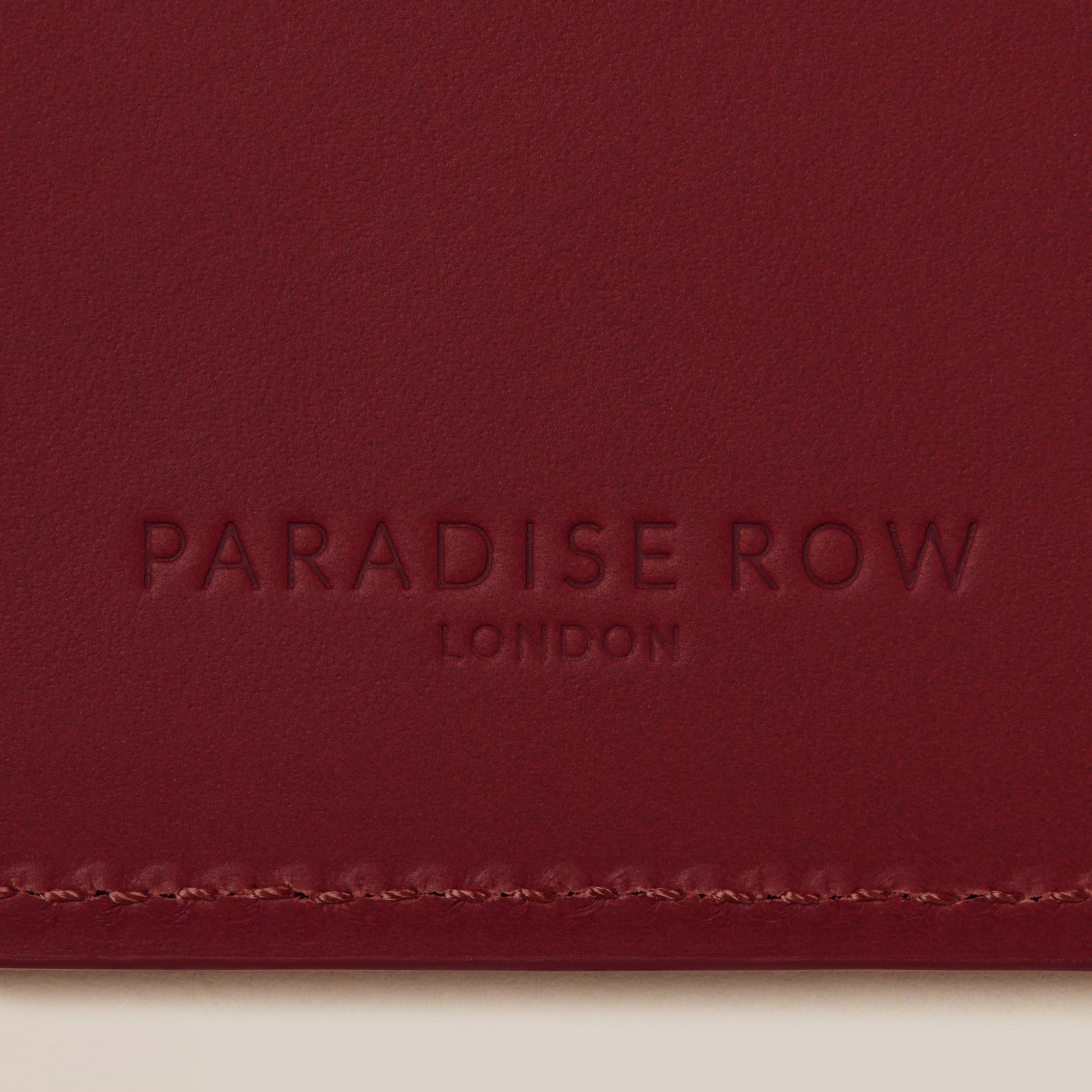 Leather Passport Holder — close-up of red leather texture and branding