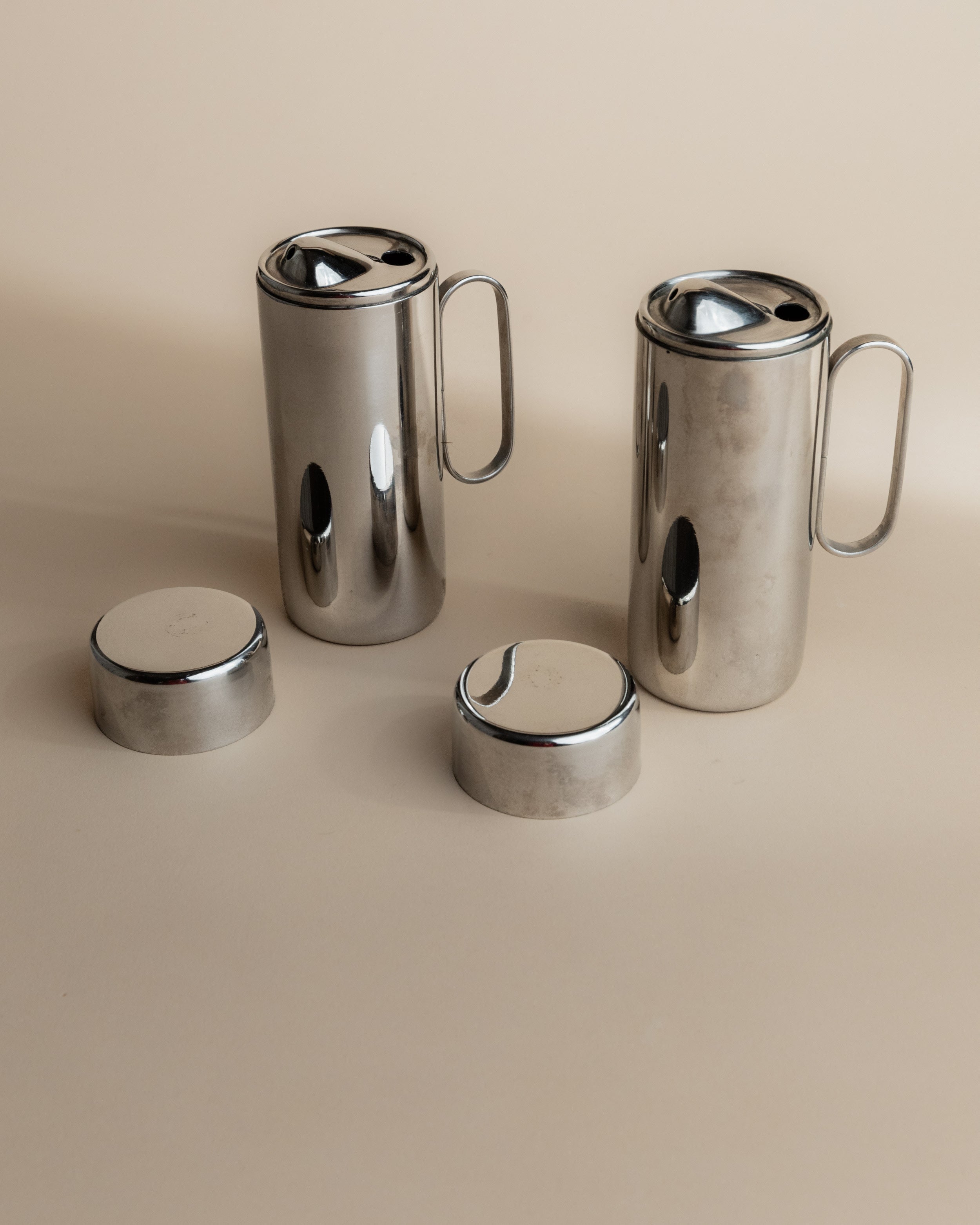 Polished stainless steel oil vinegar cruets with matching lids