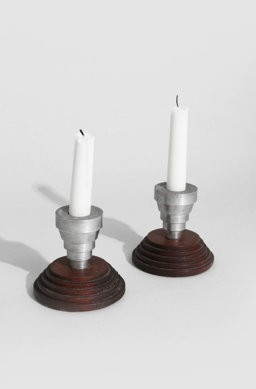 Two stair step candleholders with ridged wood bases and metal tops