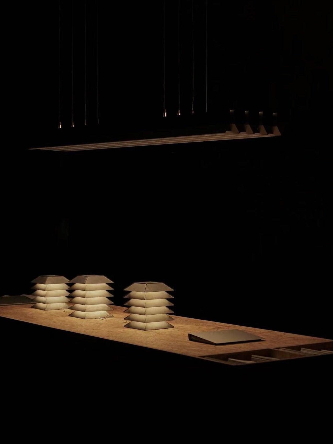 Pagoda Table Lamp — illuminated on wooden table in dark setting