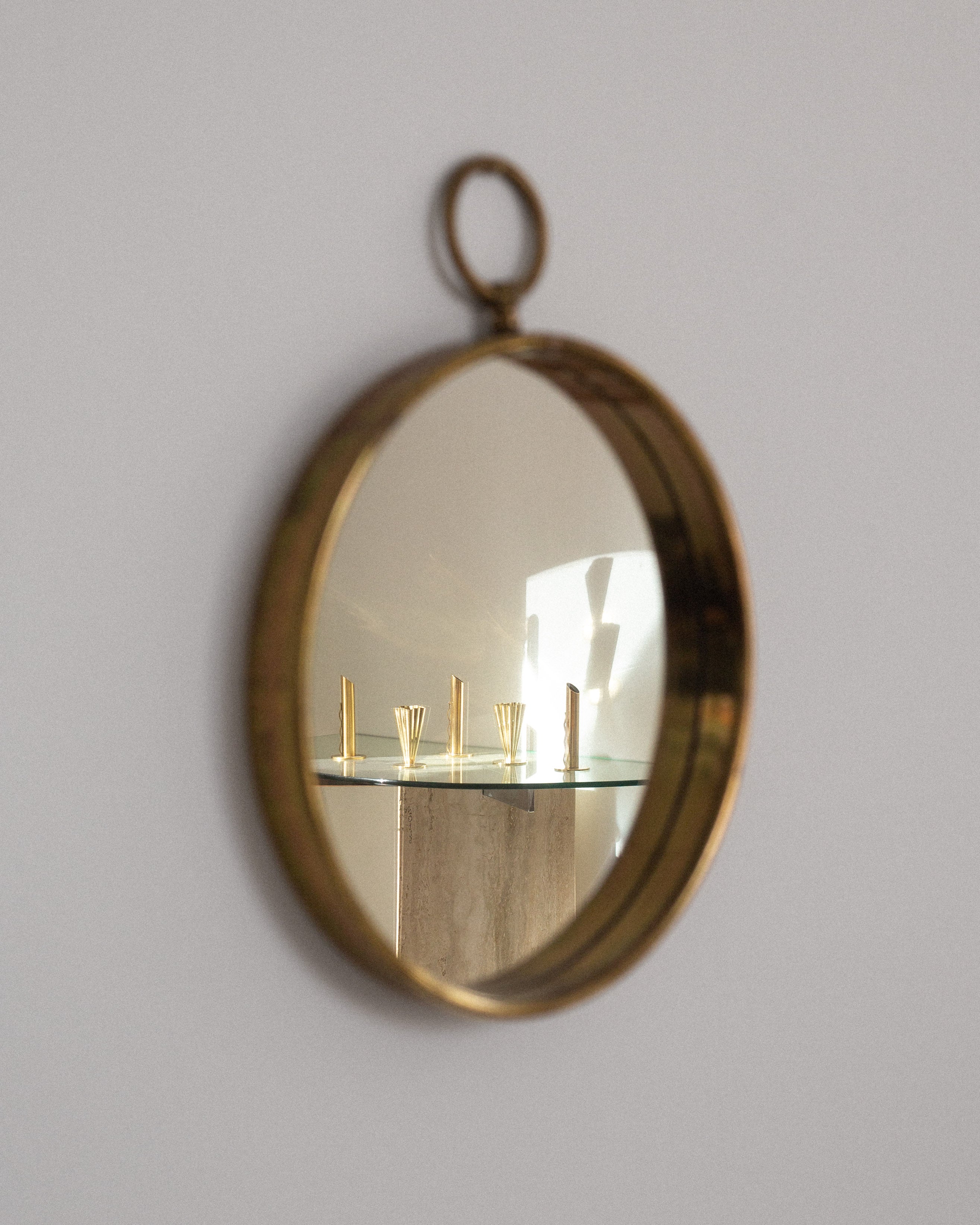 Scandinavian Mid-Century Round Brass Mirror — angled view reflecting modern decor
