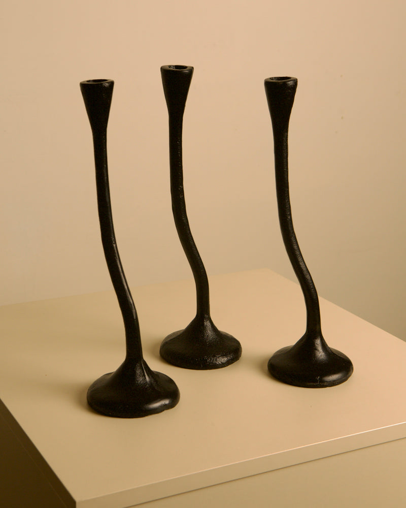 Set of 3 "Twisted" Candleholders in Black Cast Aluminum, 80s — close-up of twisted design on a neutral background