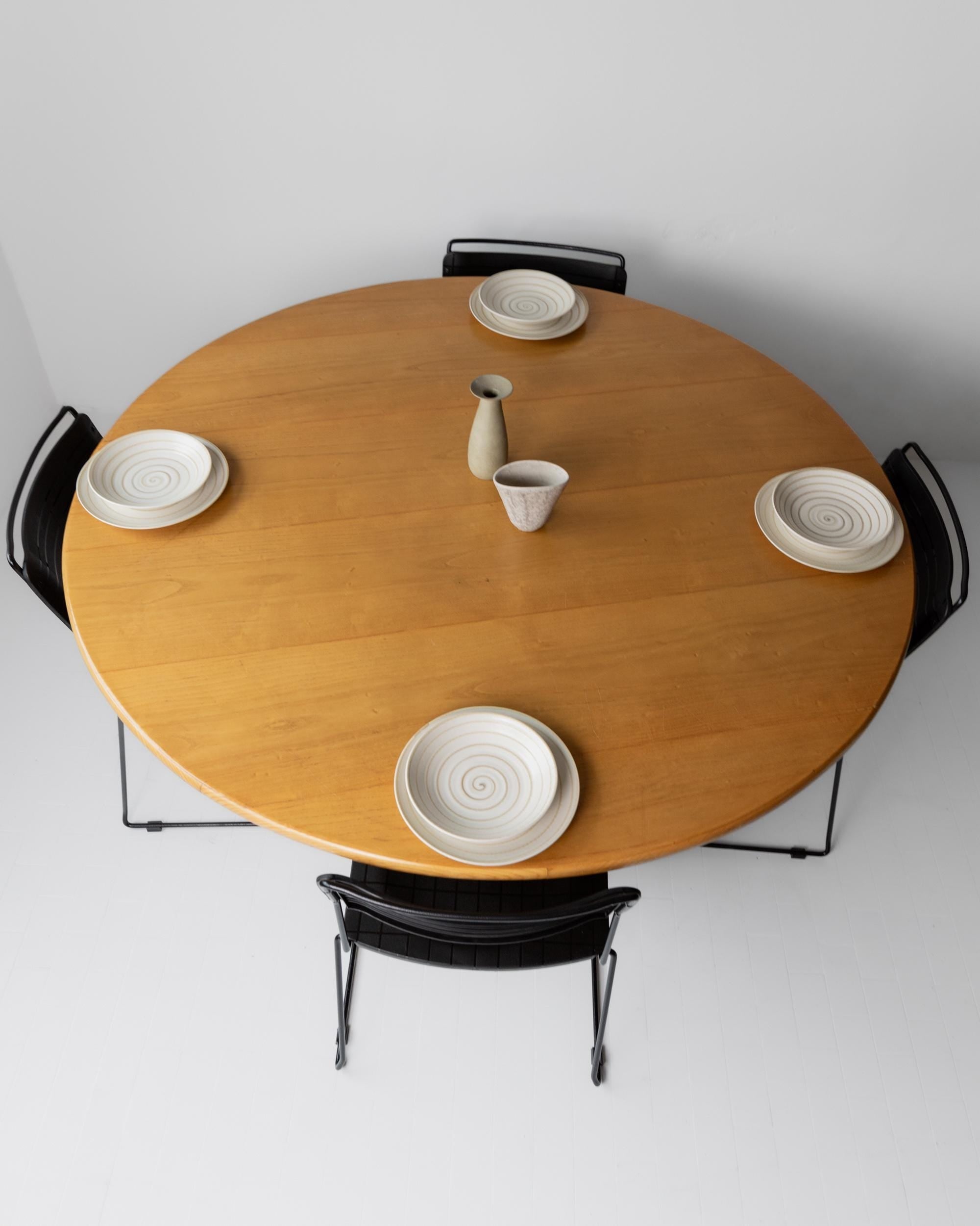 1980s Large Round Wooden Table — top view with ceramic plates arranged