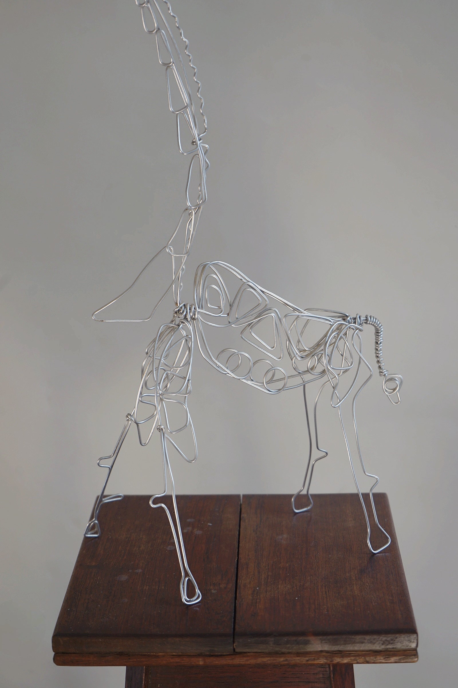 Wirework Giraffe Sculpture — side view on wooden pedestal