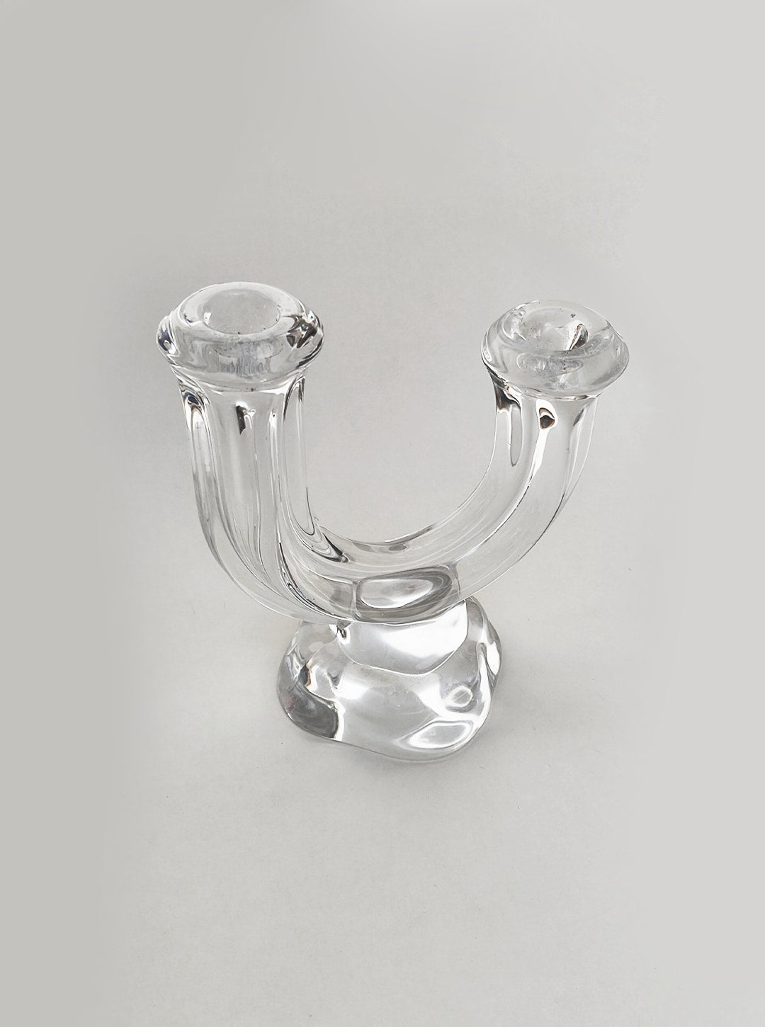 Clear glass arch-shaped candle holder with dual candle wells