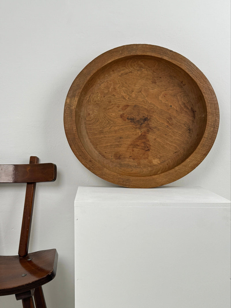 Large handcrafted wooden bowl with natural wood grain and carved rim