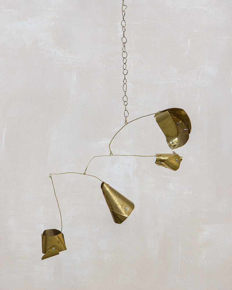 Abstract brass mobile sculpture with geometric forms suspended on delicate chains