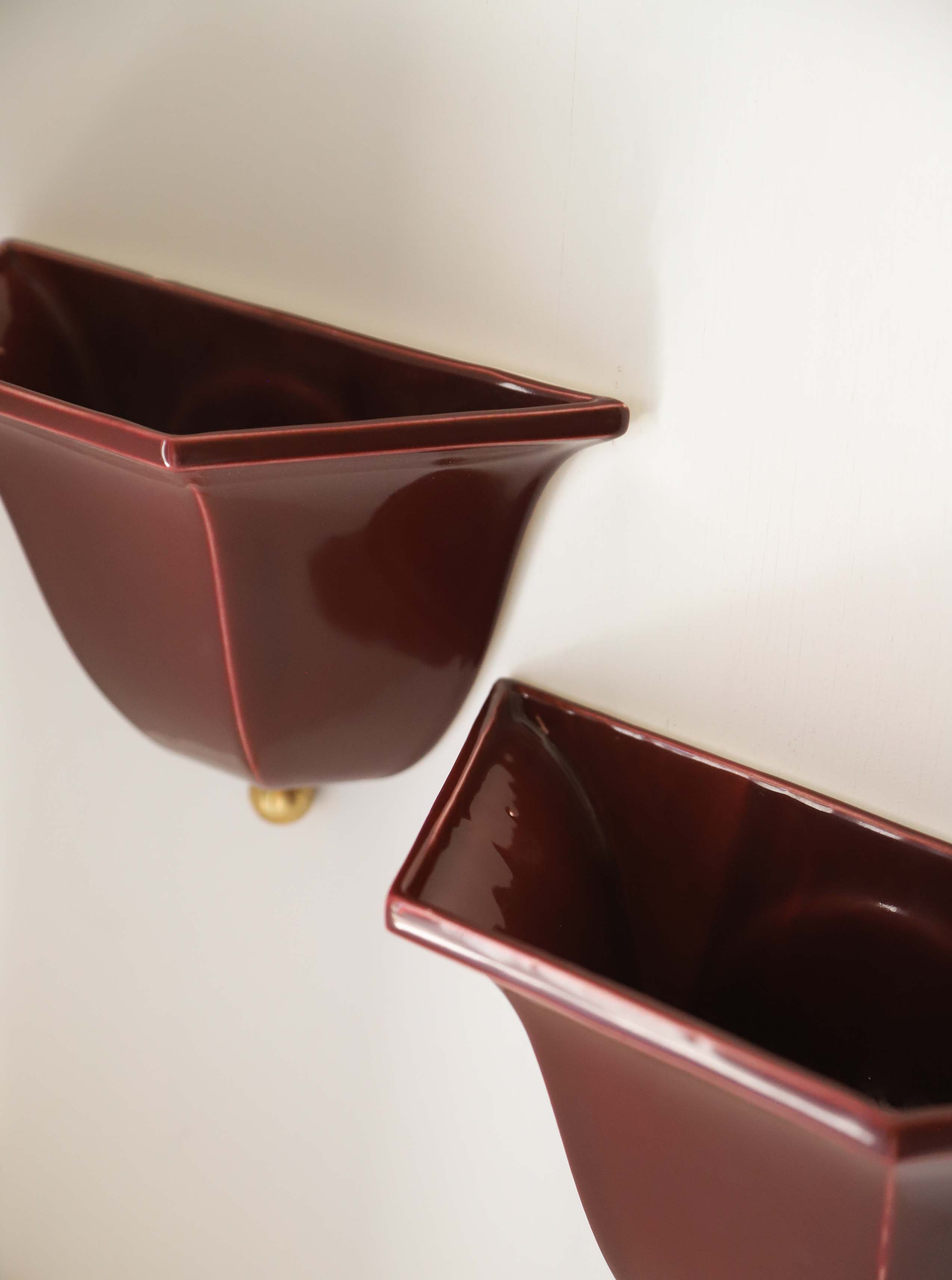 Deep burgundy ceramic wall sconce detail showing angular geometric form
