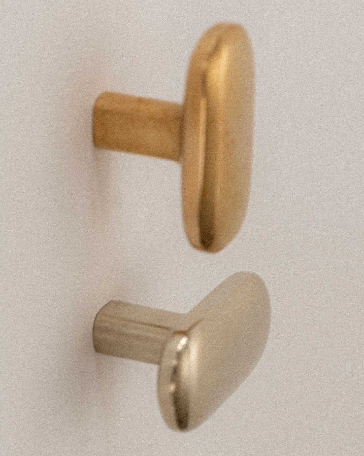 OVAL Cabinet Knob/Wall Hook — close-up of gold and silver finishes