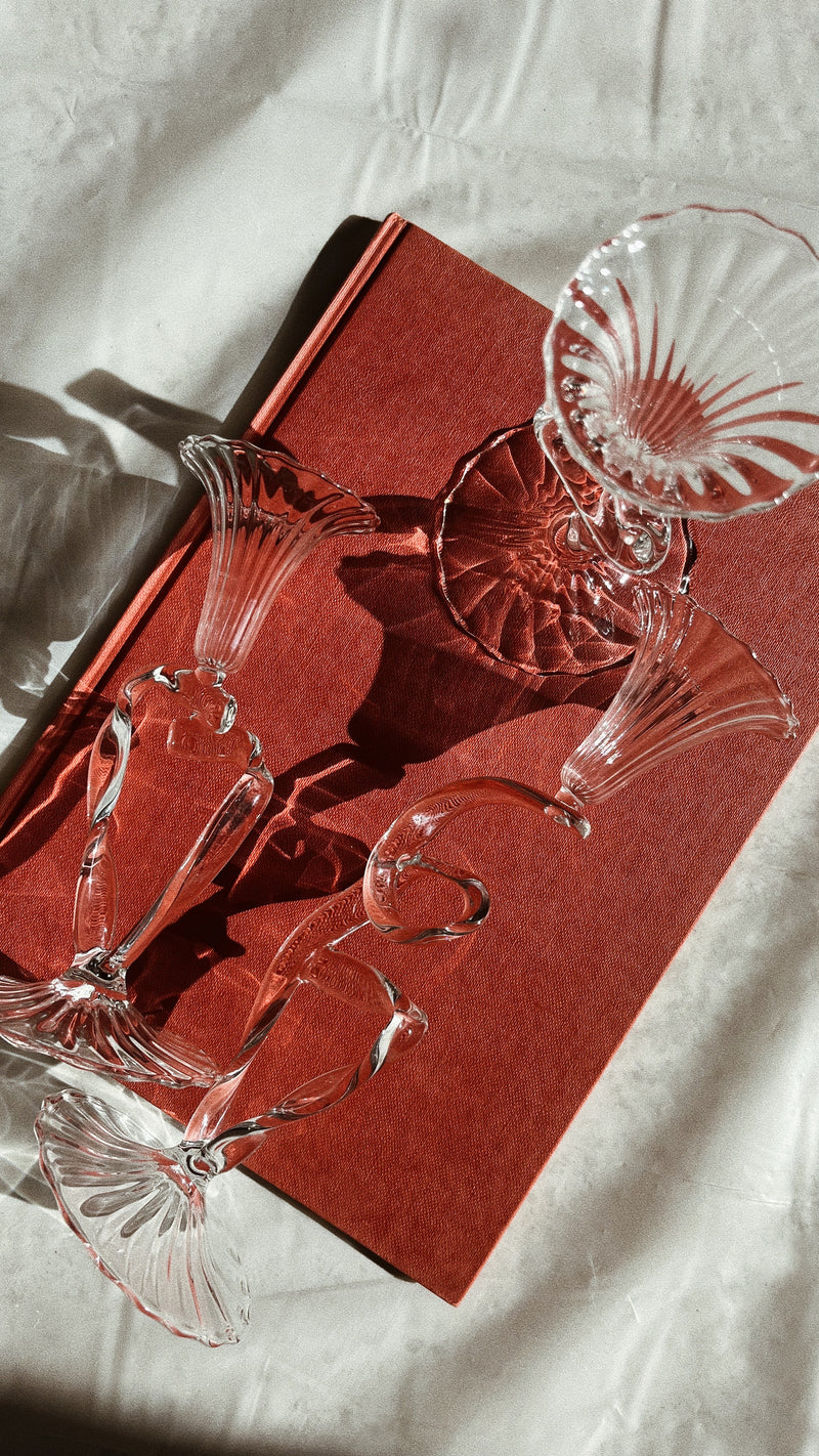 Clear glass ribbon-shaped candleholder with floral sculptural design
