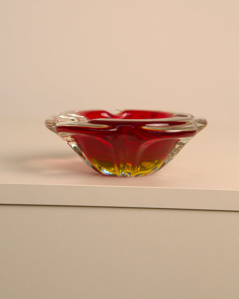 Red Murano glass ashtray with yellow base on white surface