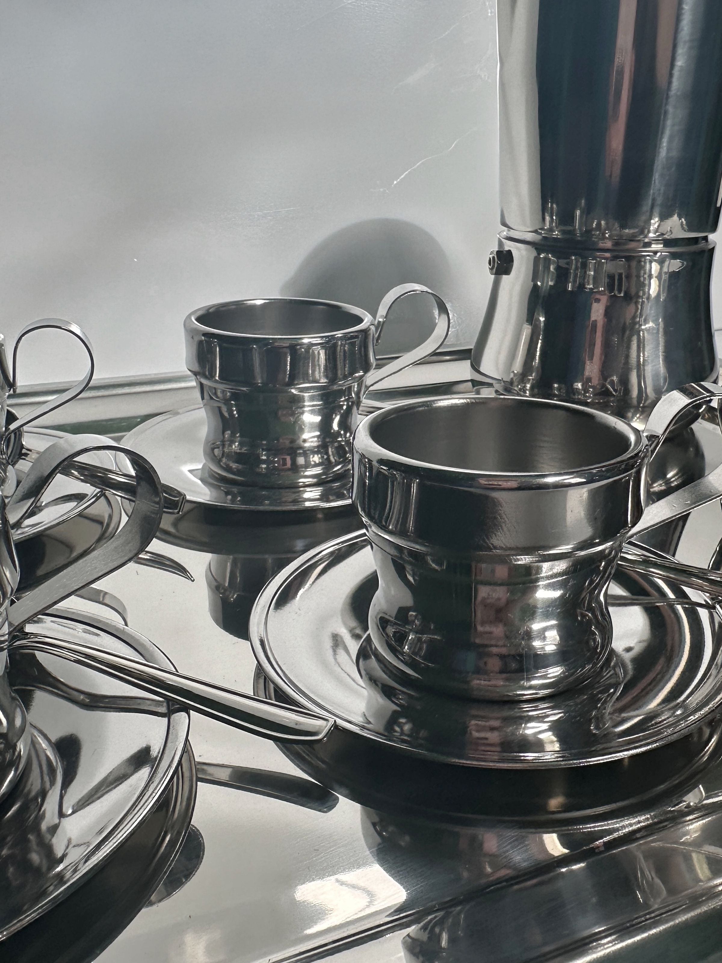 Italian Stainless Steel Coffee Set for 12 Persons — back view of polished cups and saucers