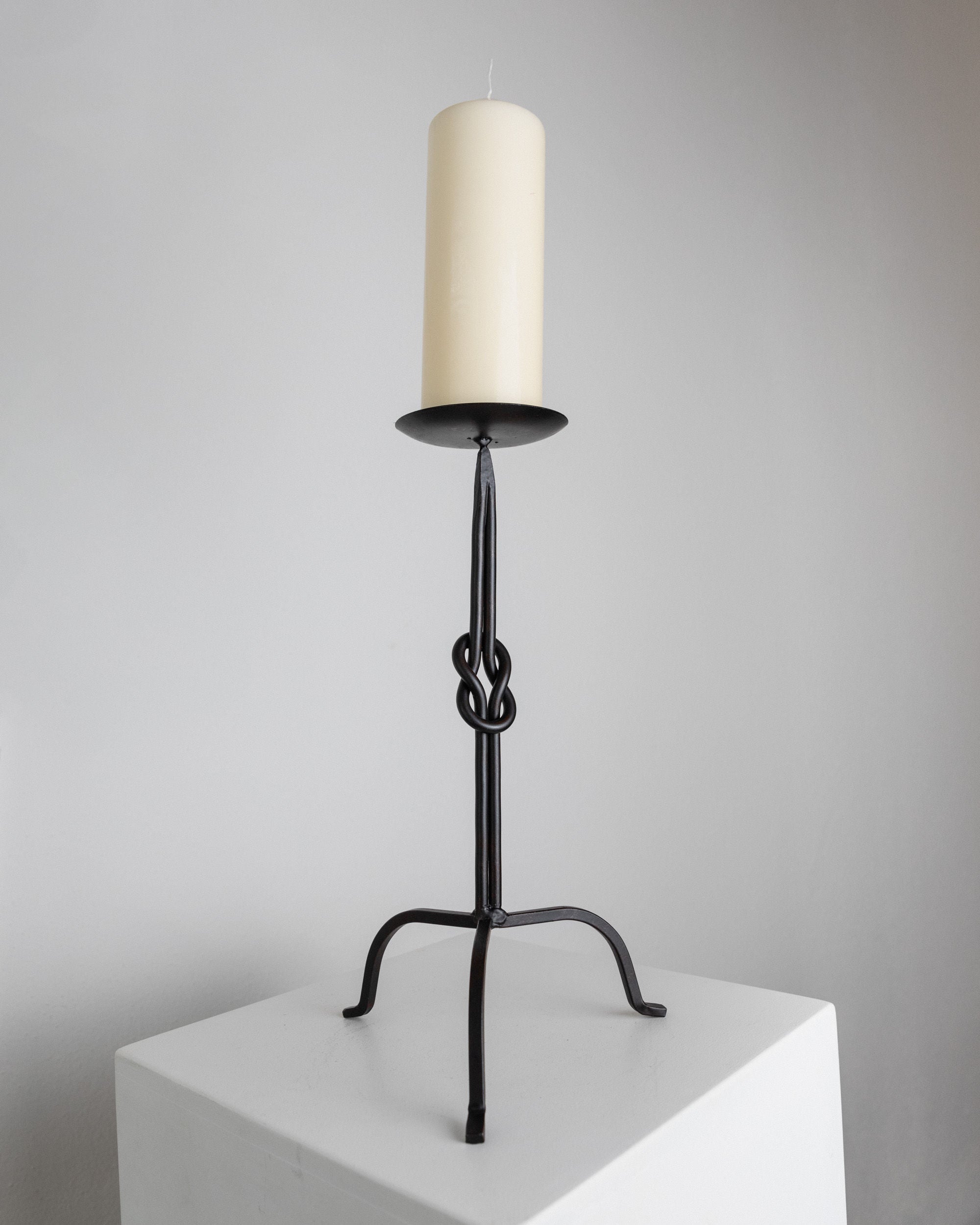 Candleholder Hand-forged Iron - Italy 1970s — close-up of black iron base with candle