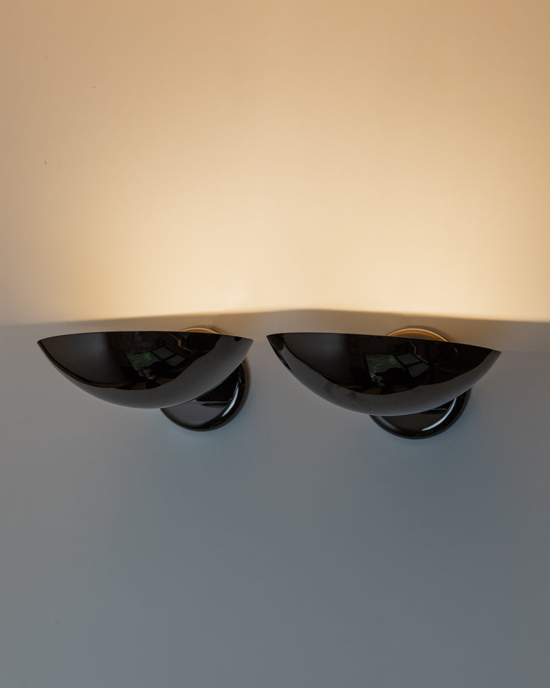 Pair of vintage black metal wall sconces with curved reflective shades