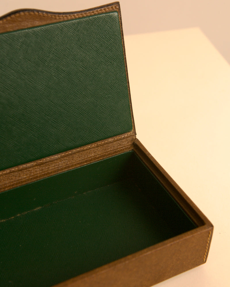 Open brown leather box interior with emerald green fabric lining