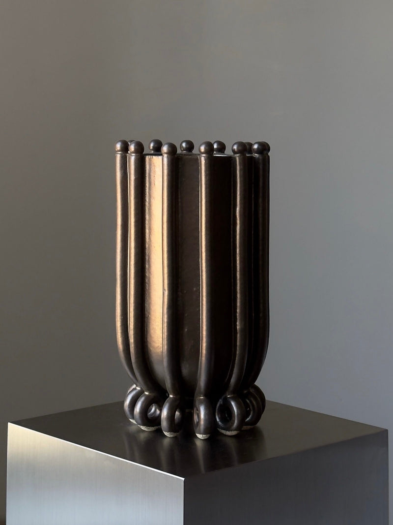 Contemporary bronze vessel sculpture with vertical ridged form by Devin Wilde