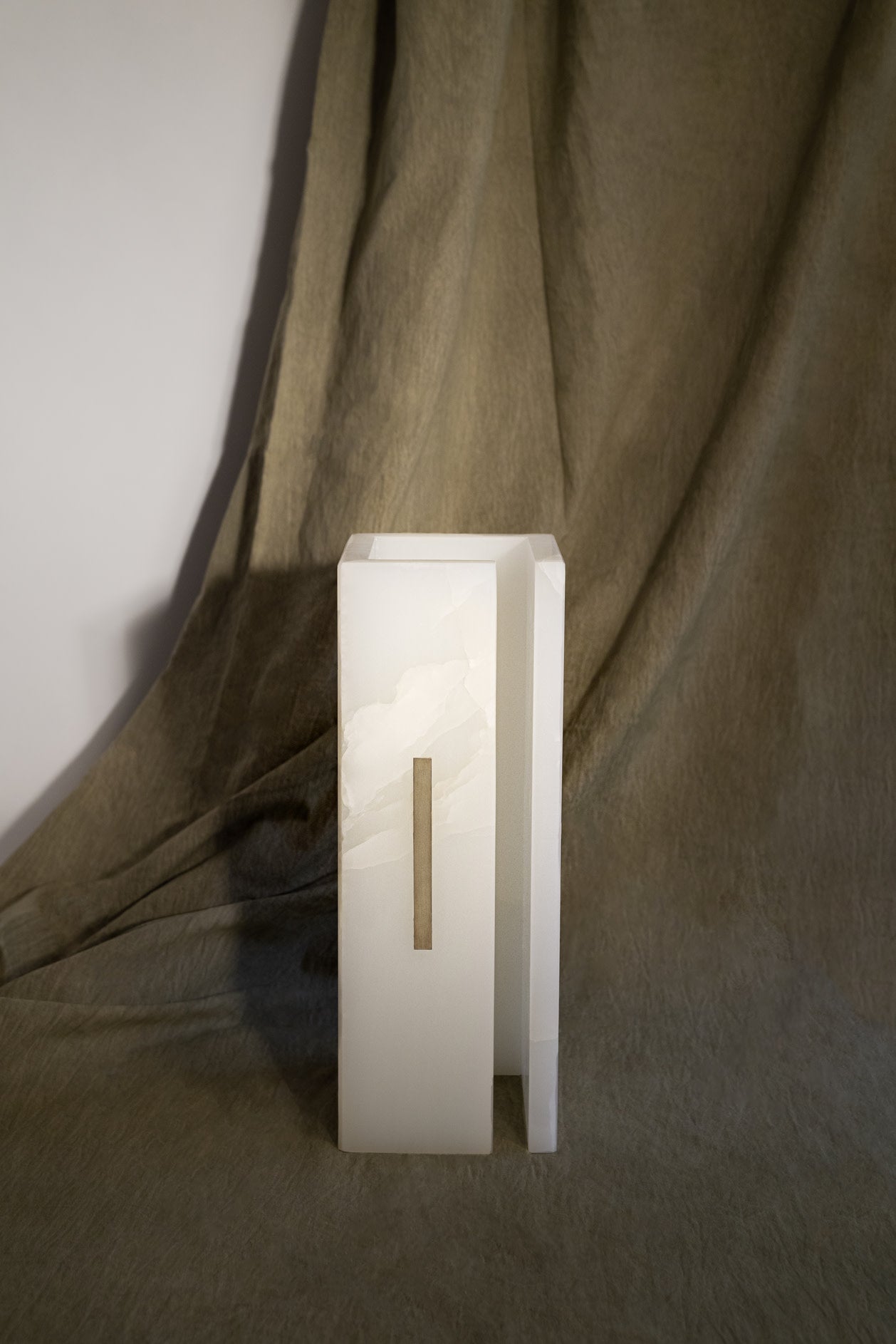 03C PURE WHITE ONIX Collectible Lighting in Stone and Onyx — angled view on textured fabric backdrop
