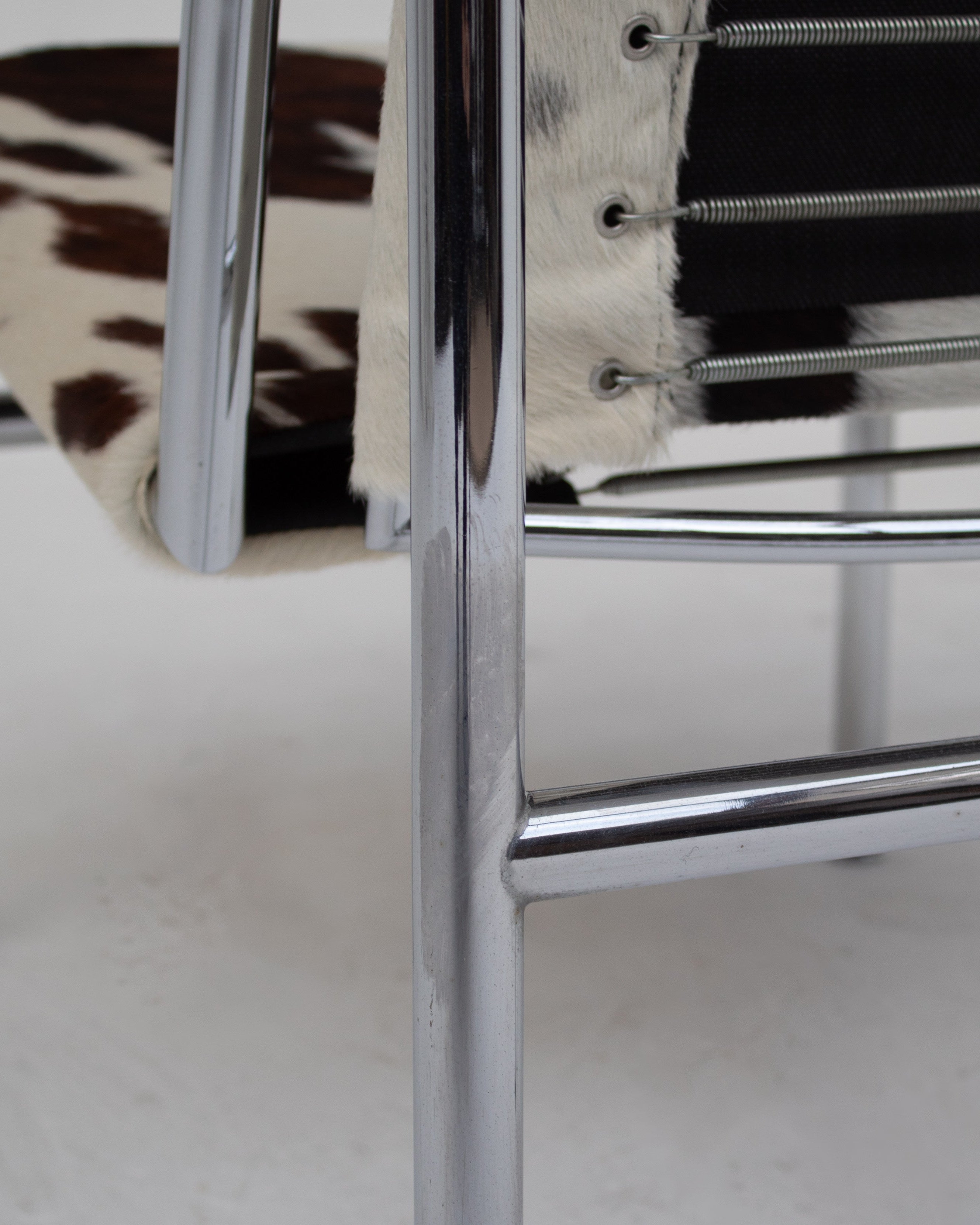 Close-up detail of chrome tubular steel frame LC1 chair legs