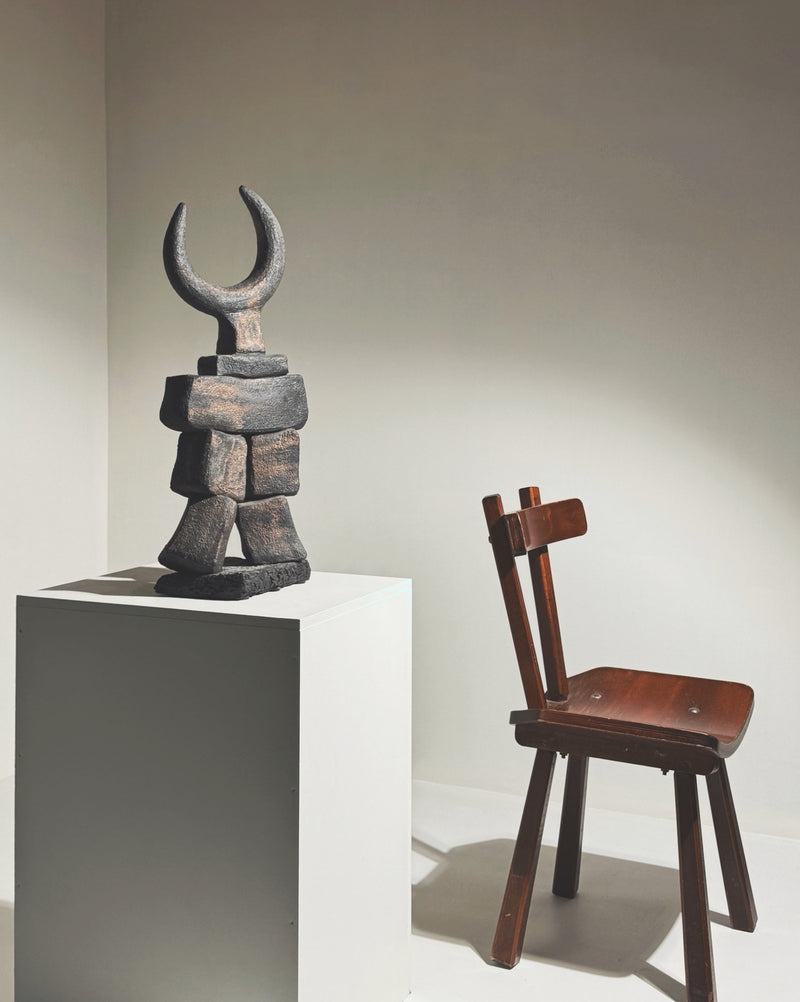 Stone Toro totem sculpture by Dominique Pouchain with wooden chair